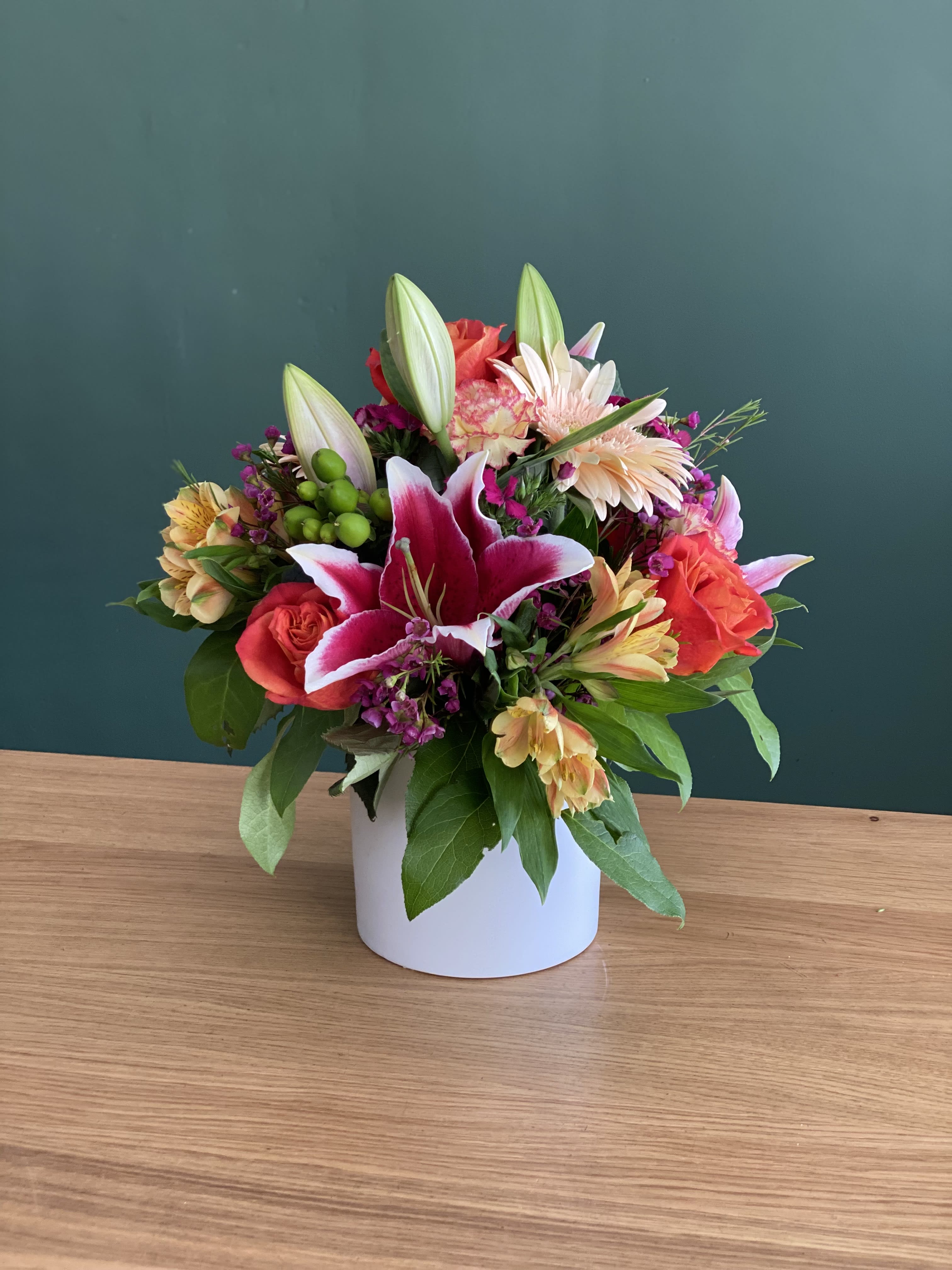 Mixed bouquet with lilies and roses in a white vase