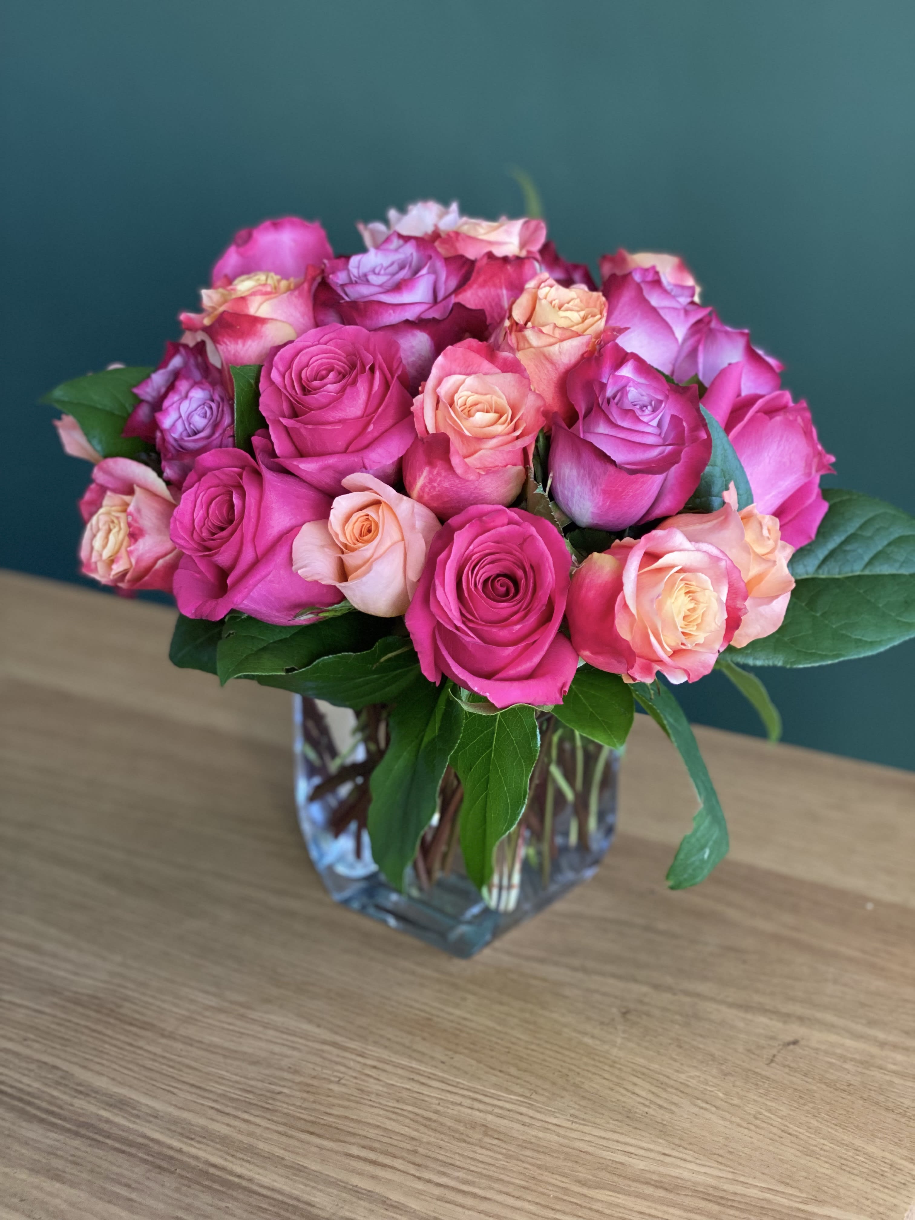 Pink and peach roses arranged in a clear glass vase