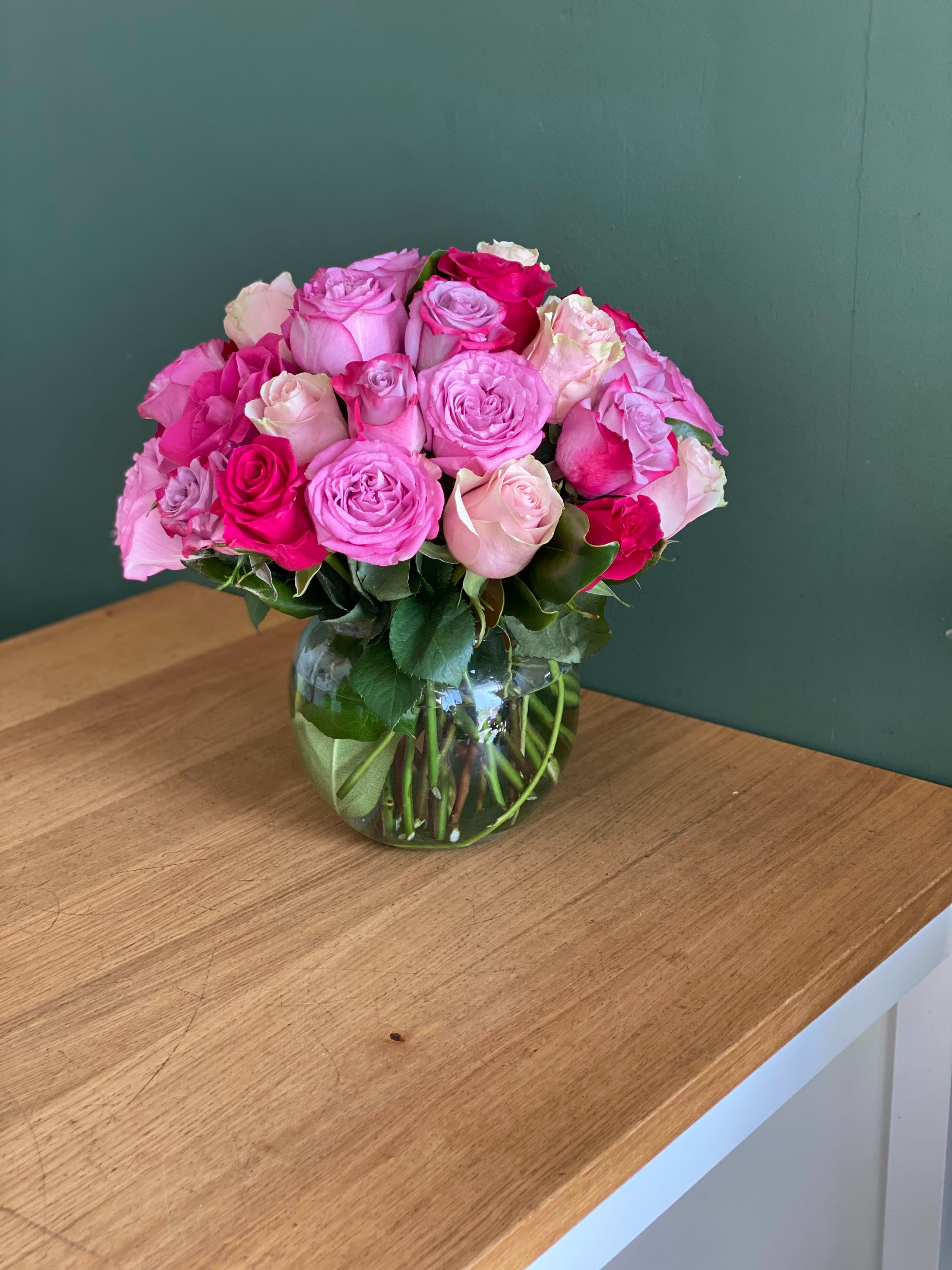 Pink and white roses arranged in a clear glass vase