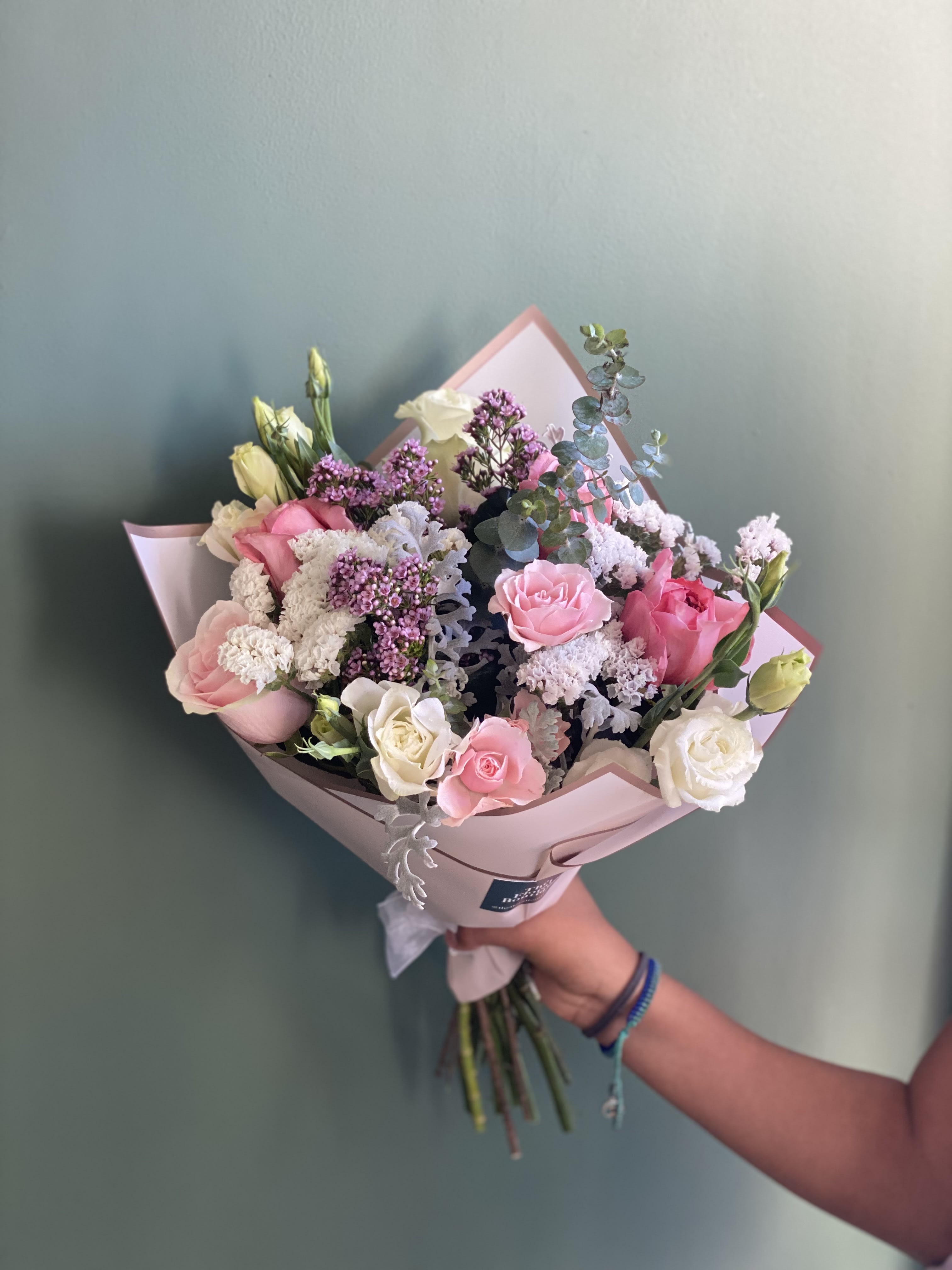 Pink and white rose bouquet with purple filler flowers and eucalyptus