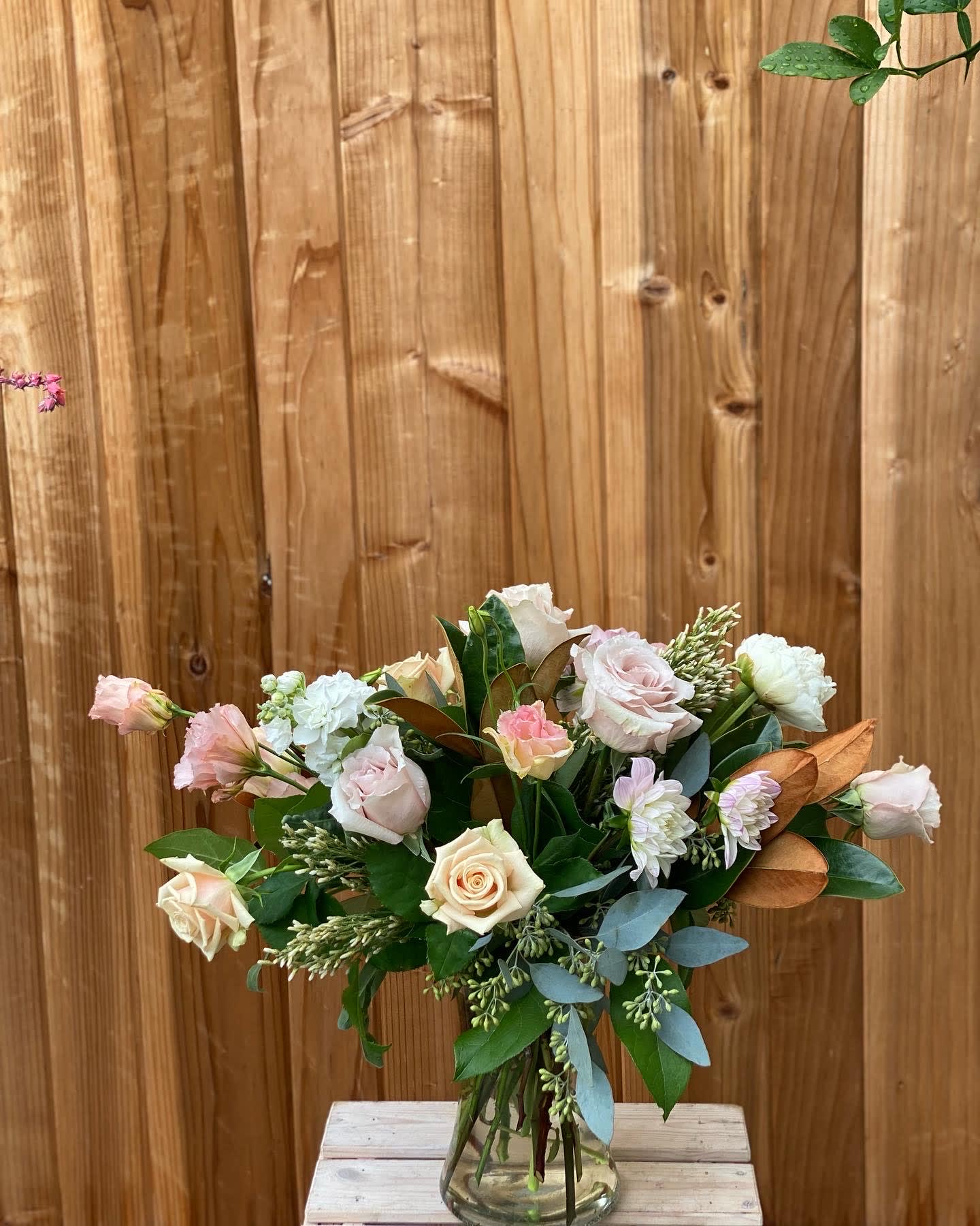 Bouquet of pale roses and white blooms in a glass vase