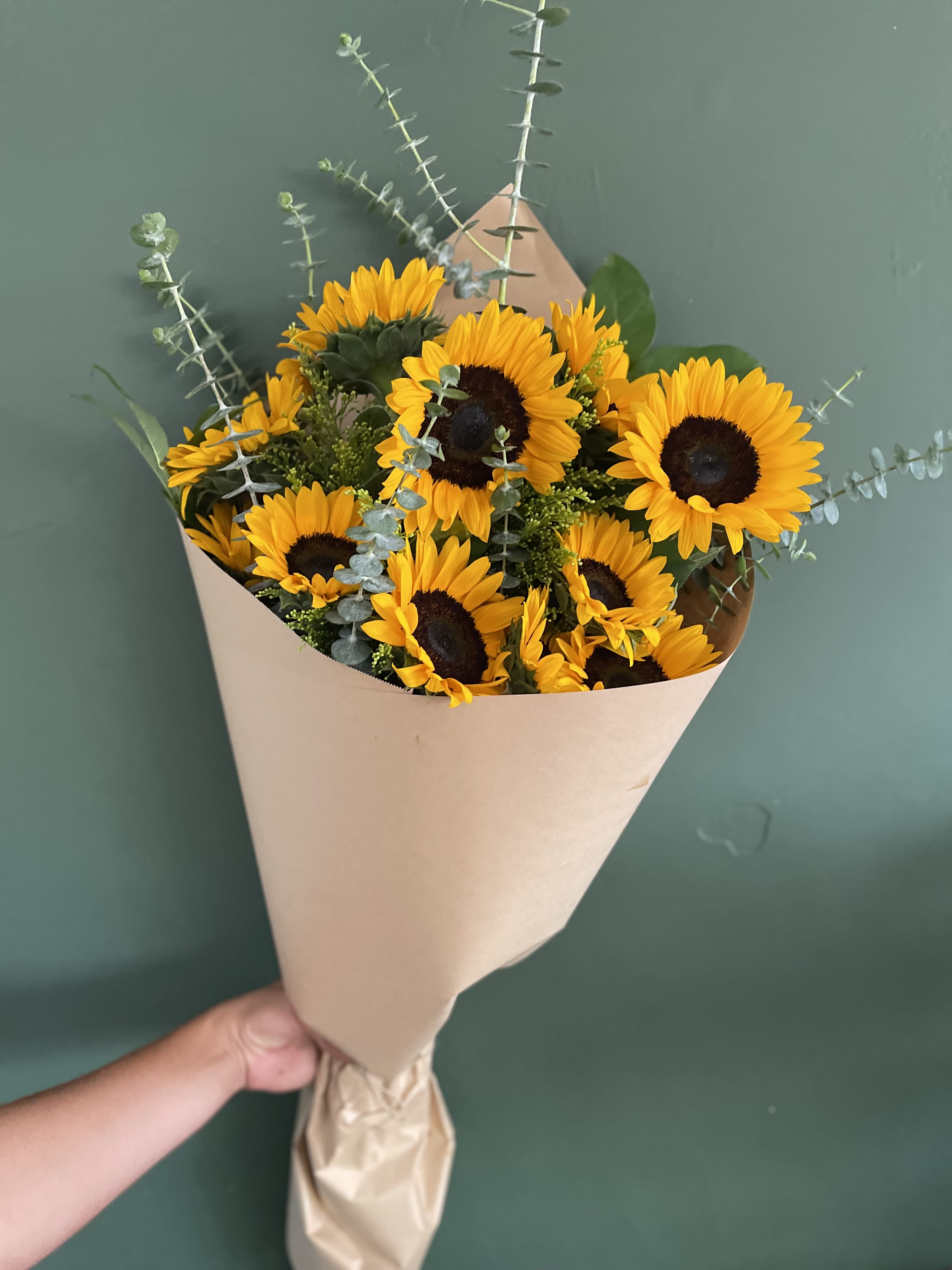 Bouquet of yellow sunflowers wrapped in beige paper