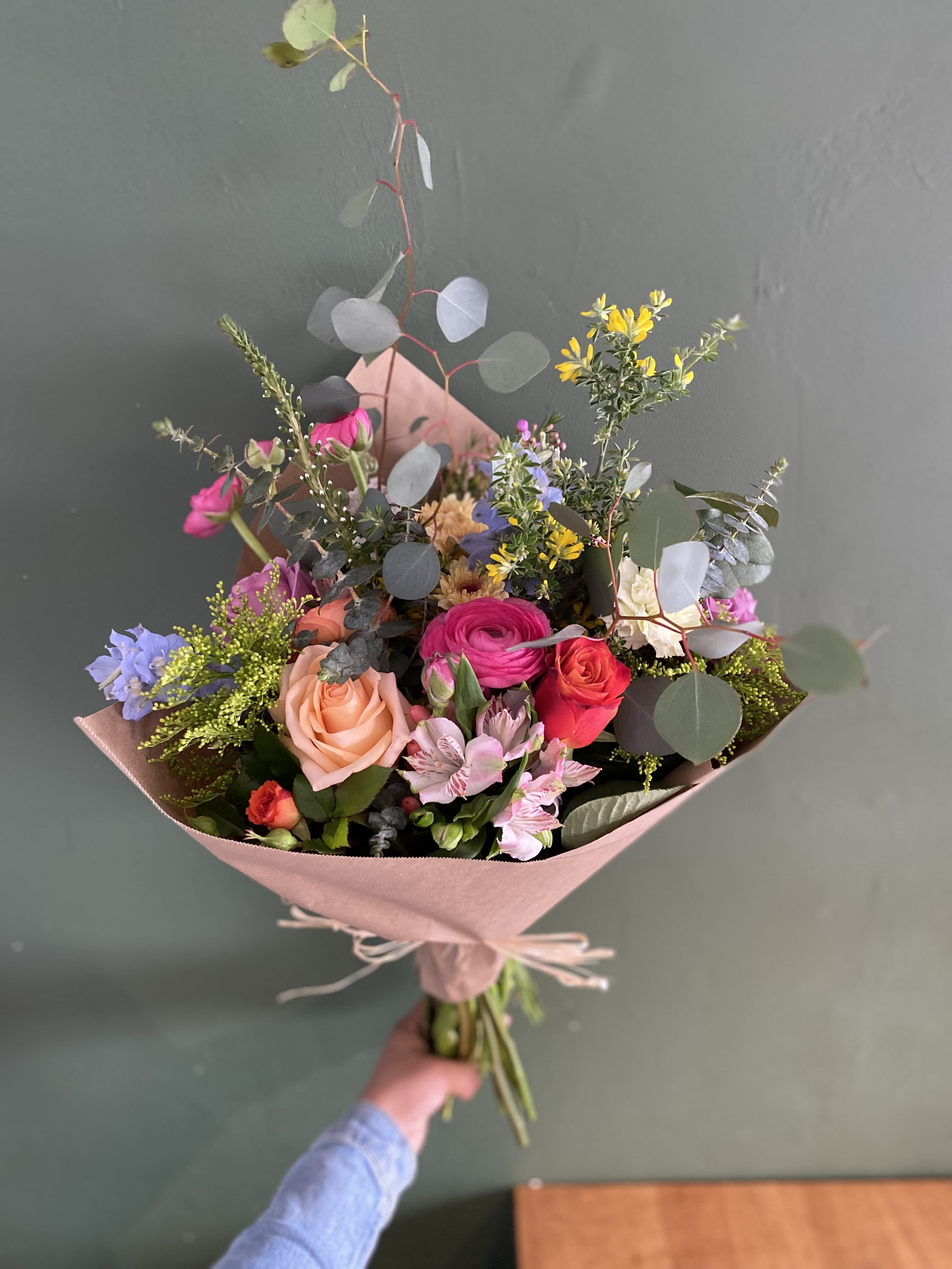 Hand-tied bouquet of mixed pink, peach, and purple flowers