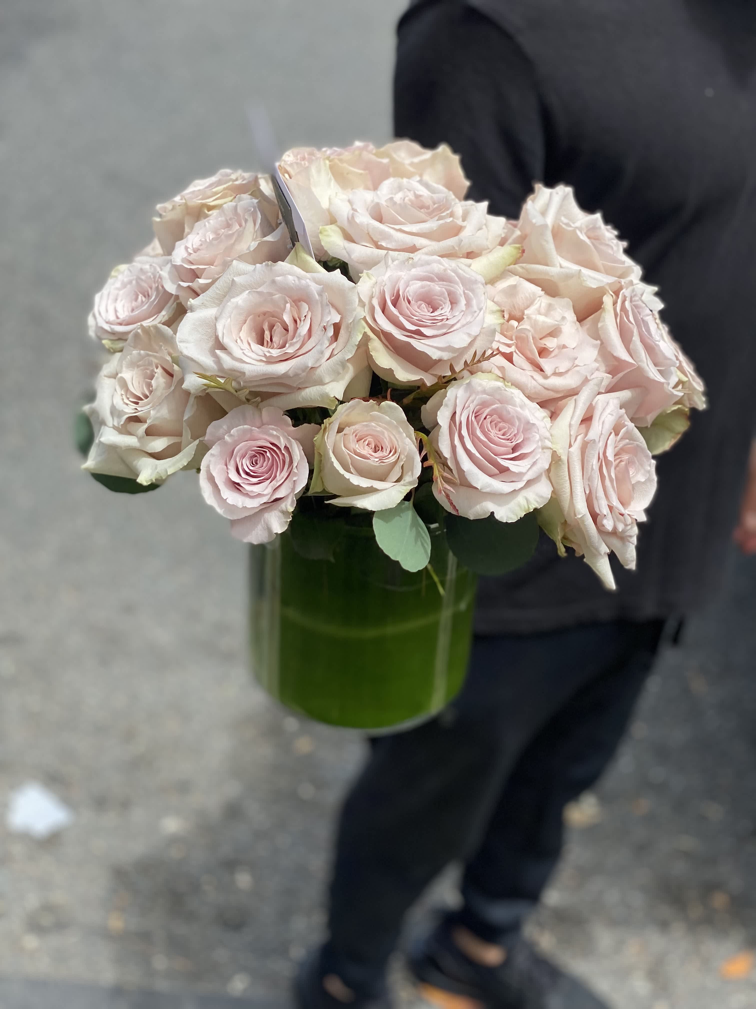 Bouquet of pale pink roses in a green glass vase