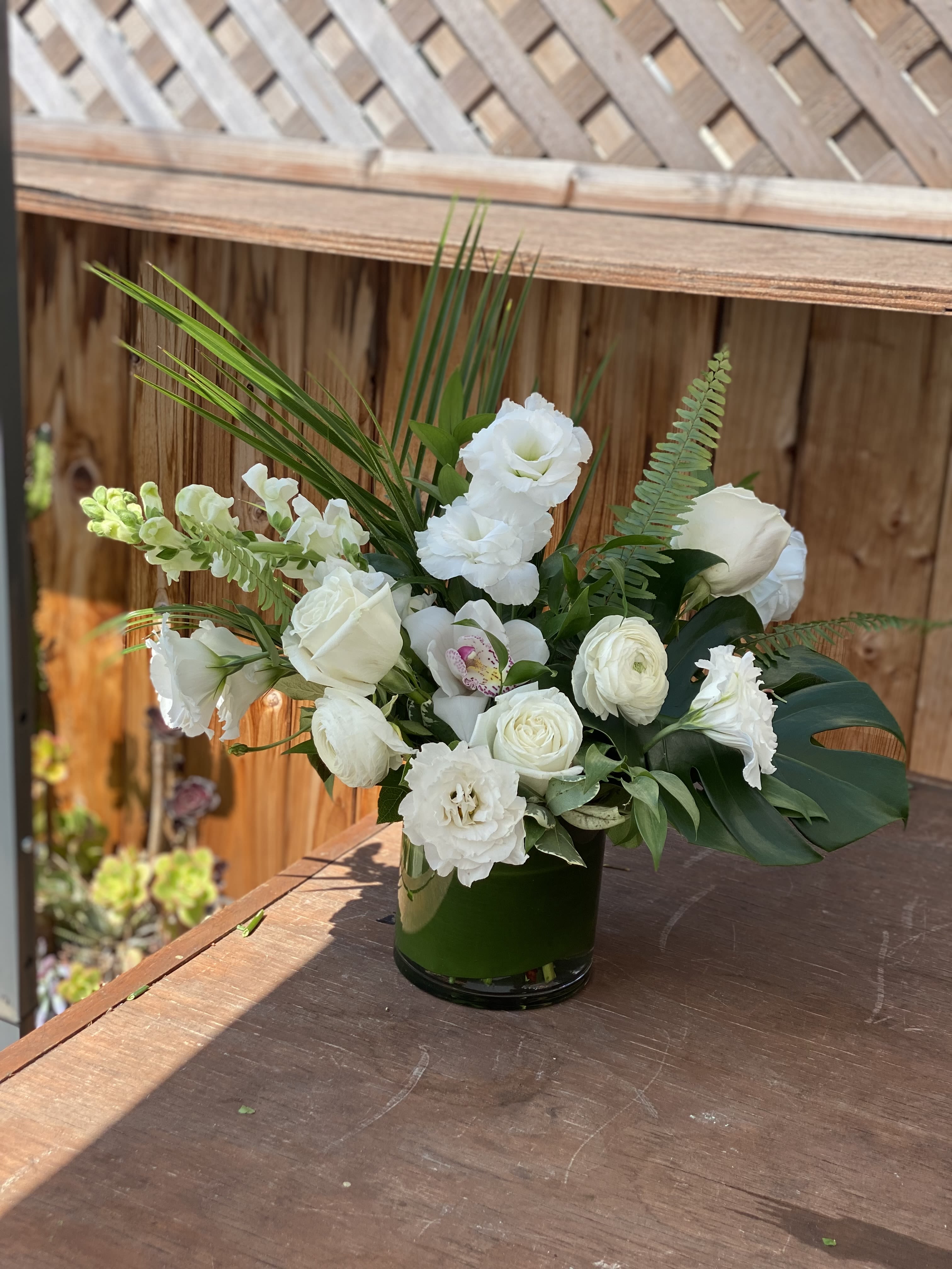 Buen dia - The buen dia arrangement is a perfect gift for moments that call for quiet reflection, heartfelt sympathies, or a gesture of pure. Comes with mix tropical leafs, roses, snap dragon, orchid cymbidium and much more.   Although the actual bouquet may not precisely match the photo, its temperament will. Occasionally, substitutions of flowers or containers happen due to weather, seasonality and market conditions which may affect availability