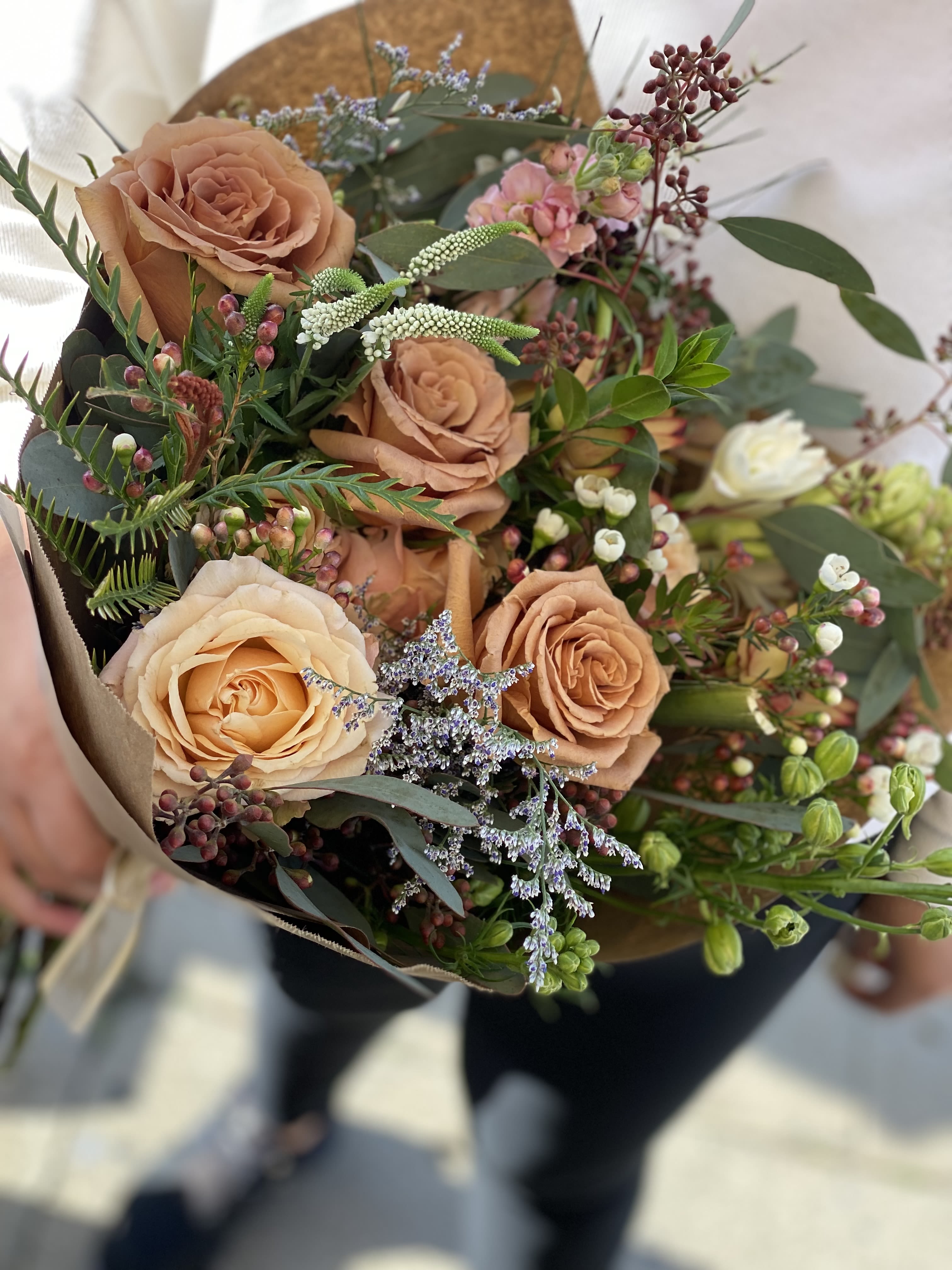 Bouquet of peach roses with small pink and white filler flowers