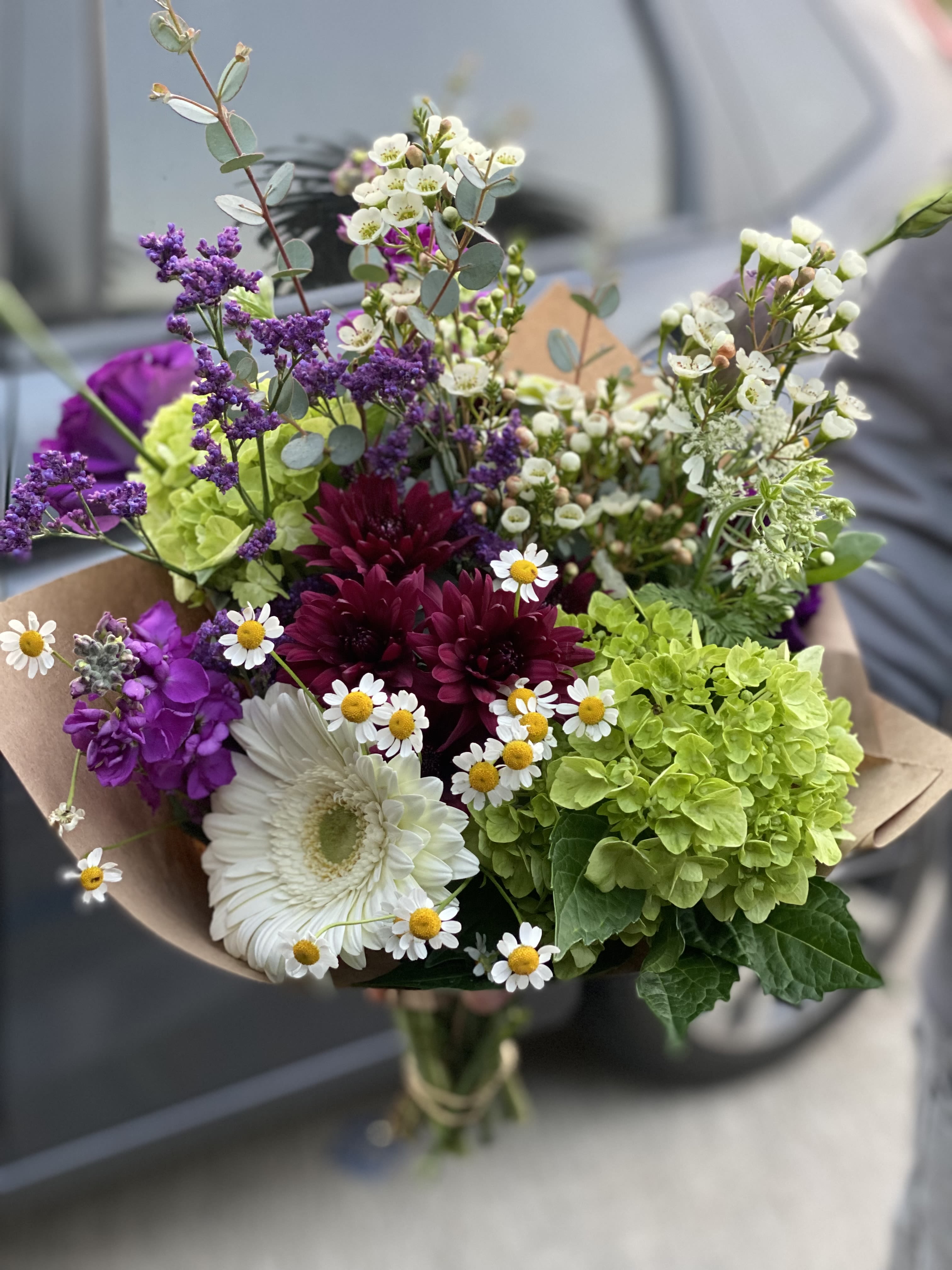 Mixed bouquet with white gerbera, purple blooms, and green hydrangea