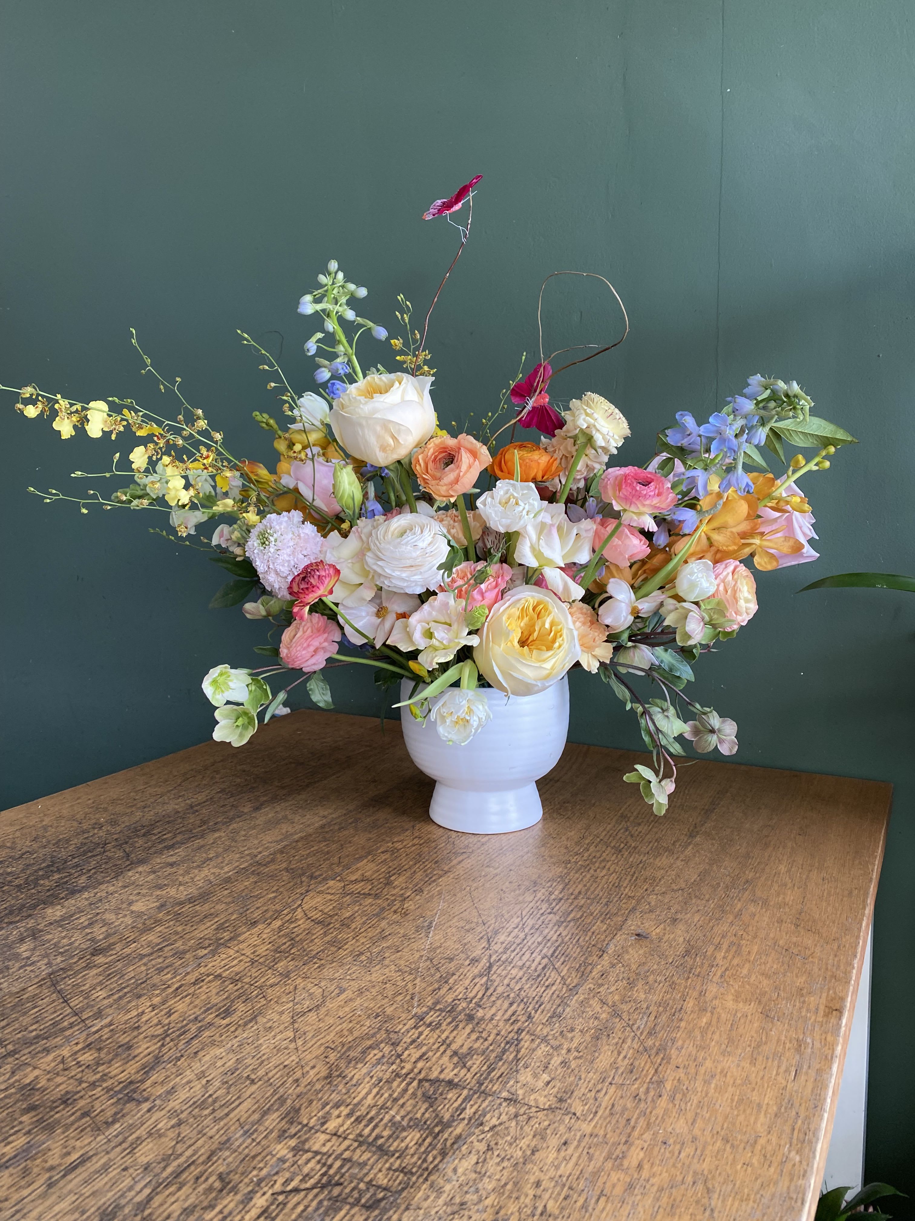 L.A Sunrise  - Beautiful in season blooms, arranged in a white ceramic pot. 