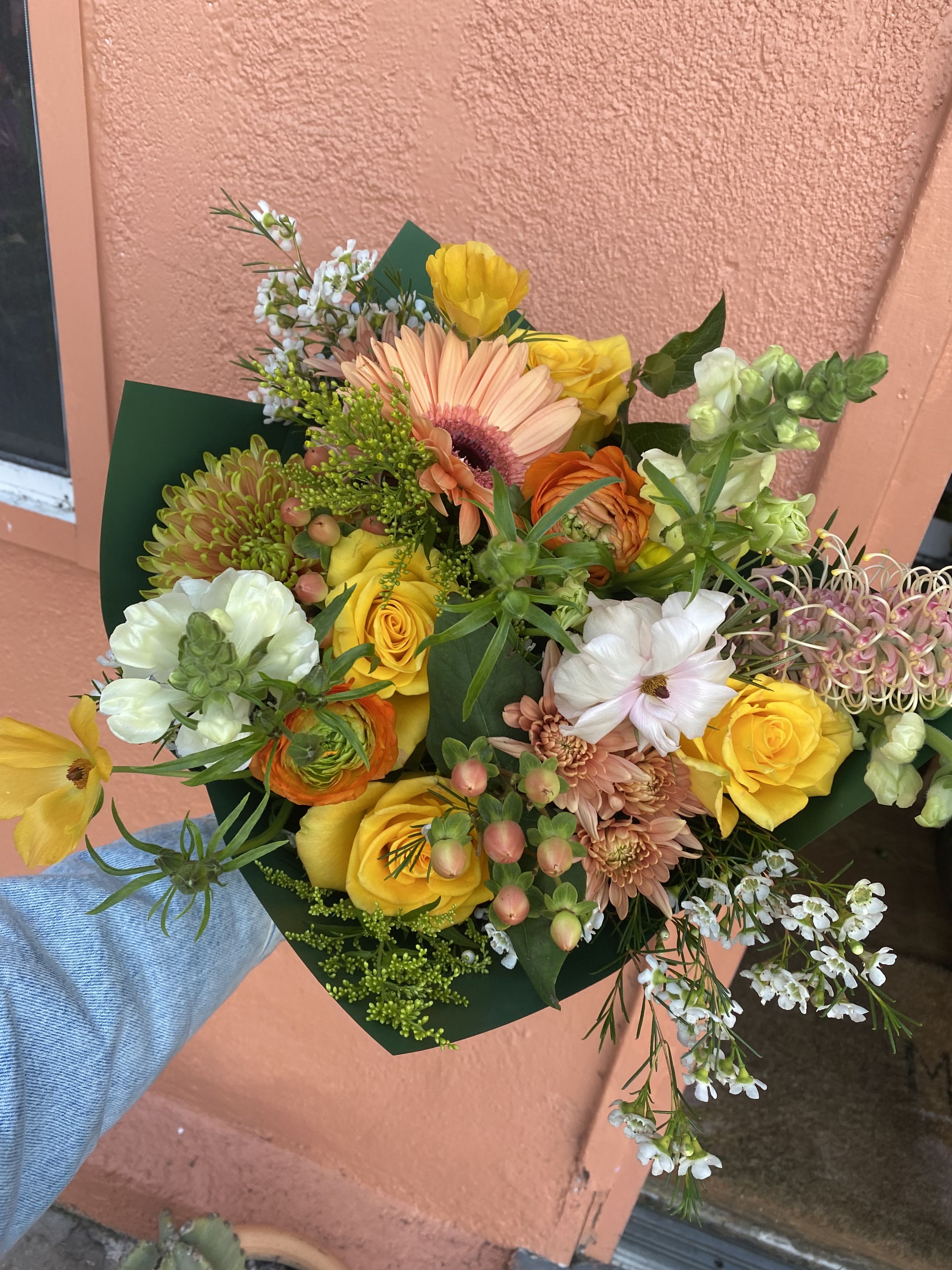Hand-tied bouquet of yellow, peach, and white mixed flowers