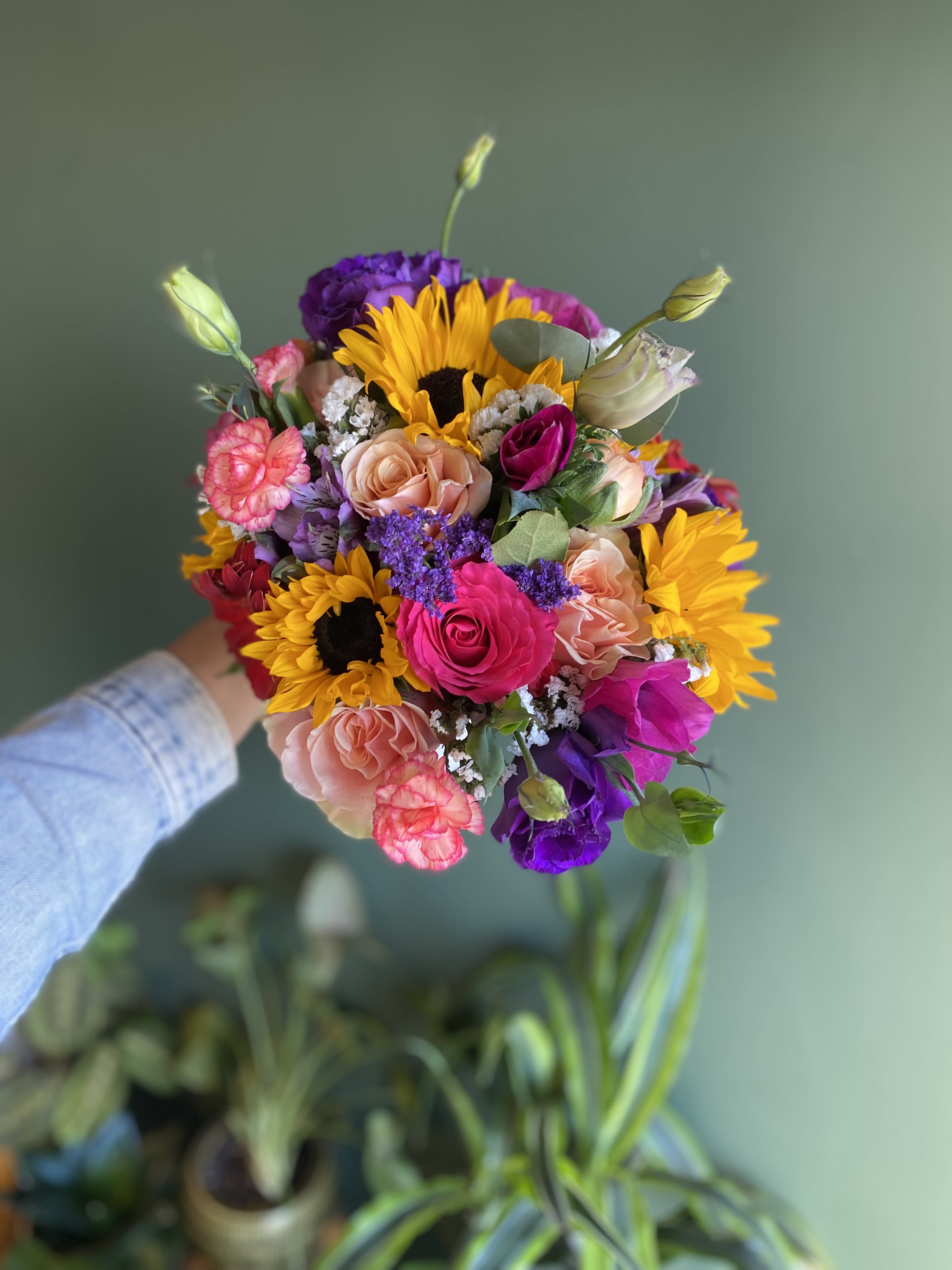 Handheld bouquet with sunflowers, roses, and purple blooms