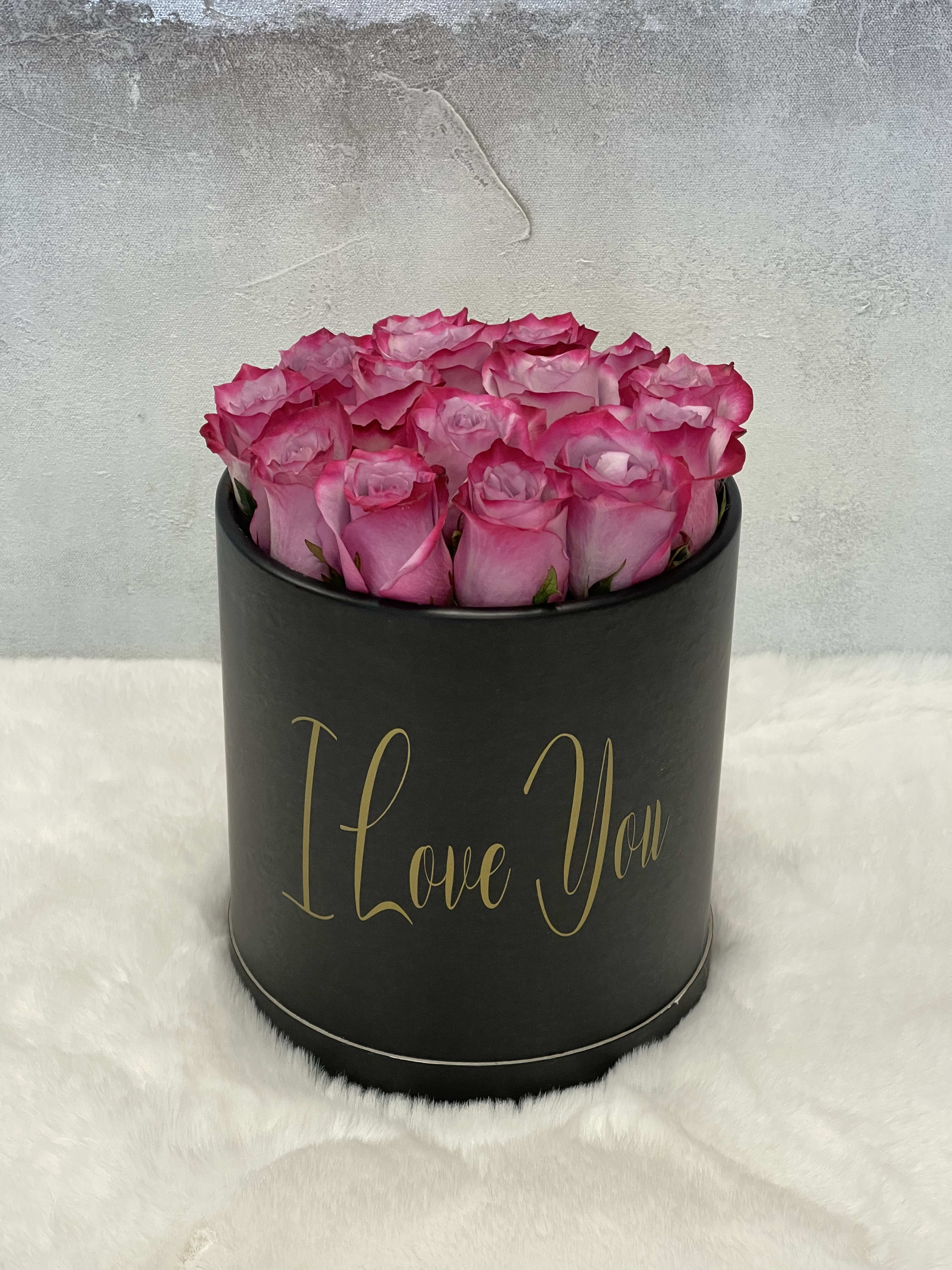 Round black hat box filled with pink roses and gold I Love You text on the front