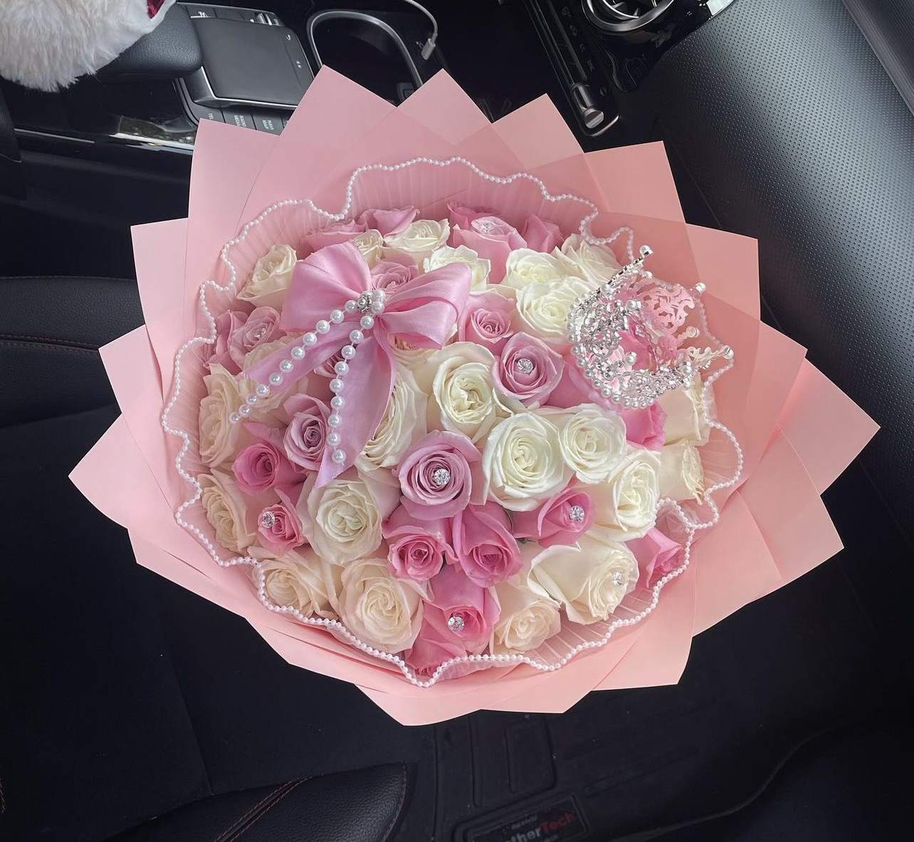 Pink and white rose bouquet wrapped in pink paper with pearl accents