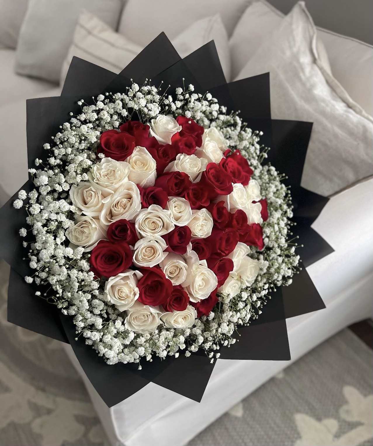 Bouquet of red and white roses wrapped in black paper