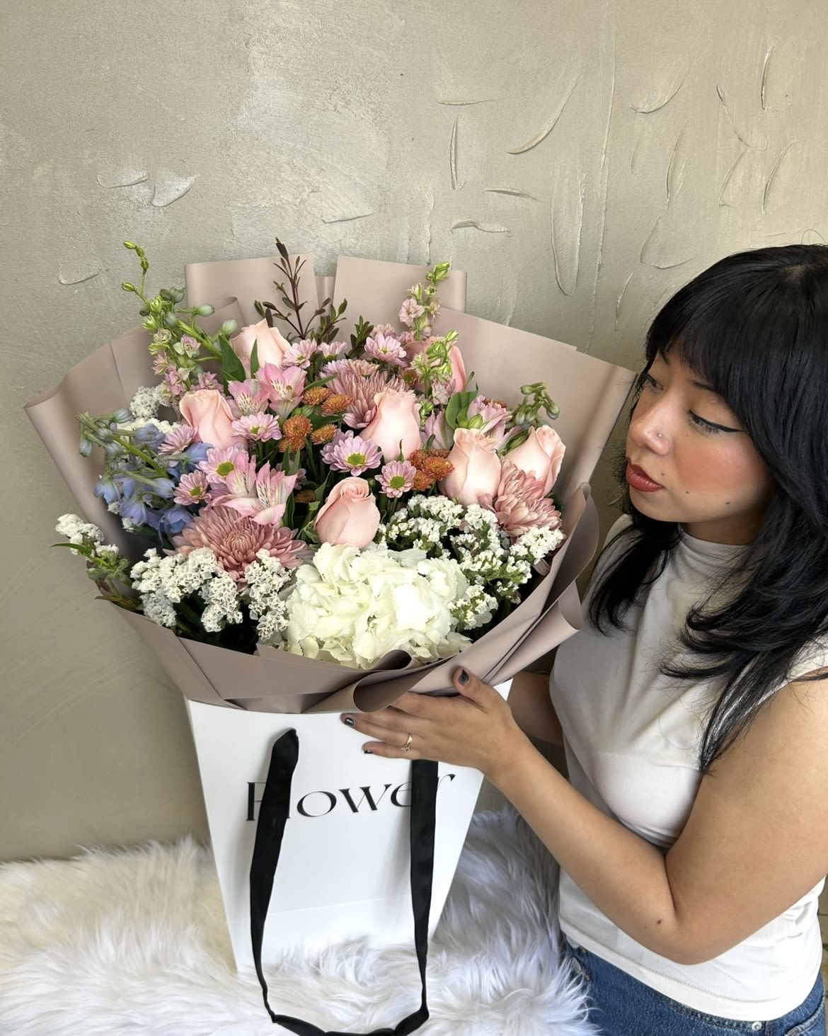 Large bouquet of pink and white flowers in mauve wrapping