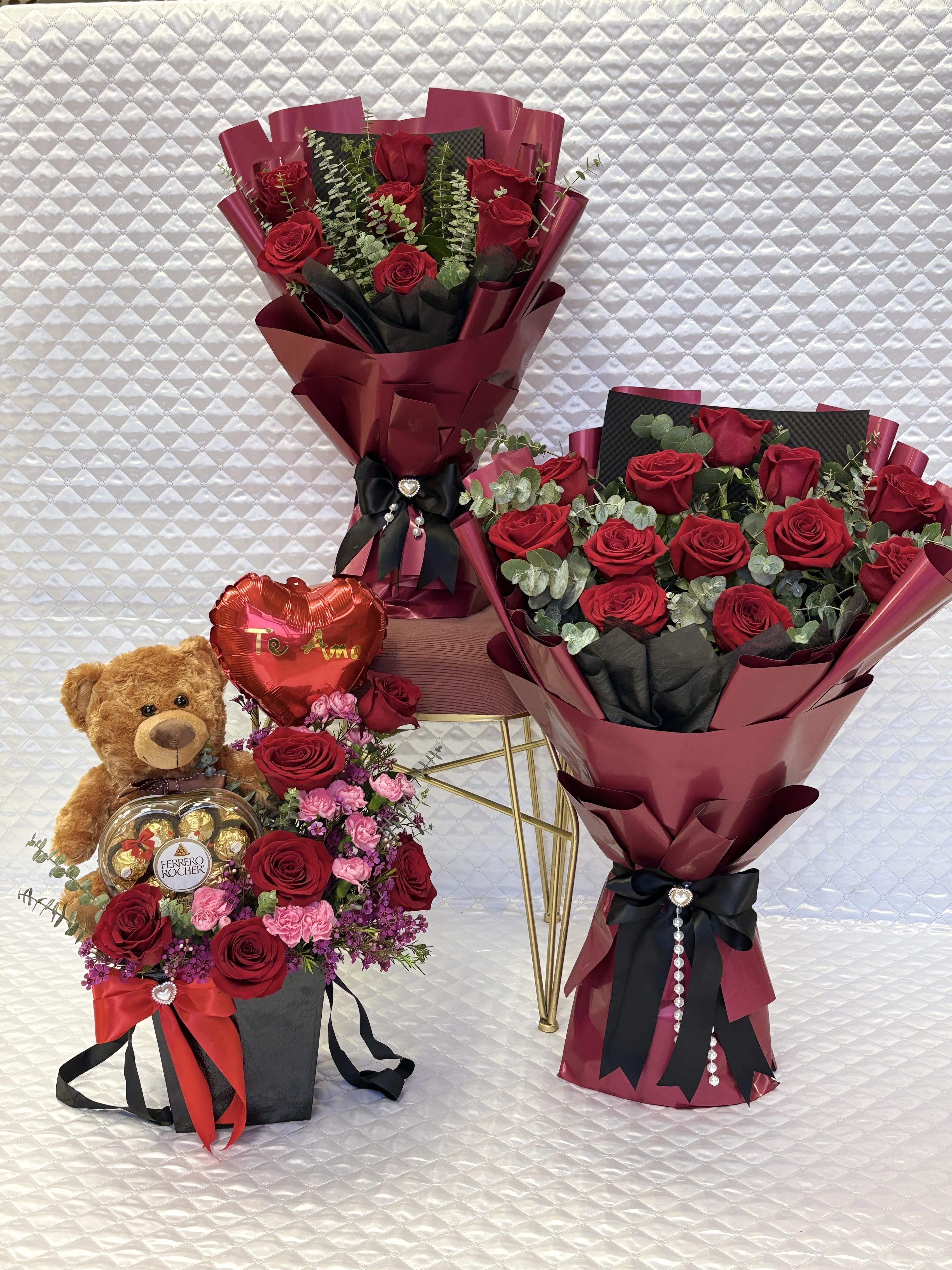 Bouquets of red roses with a teddy bear and heart-shaped chocolate box