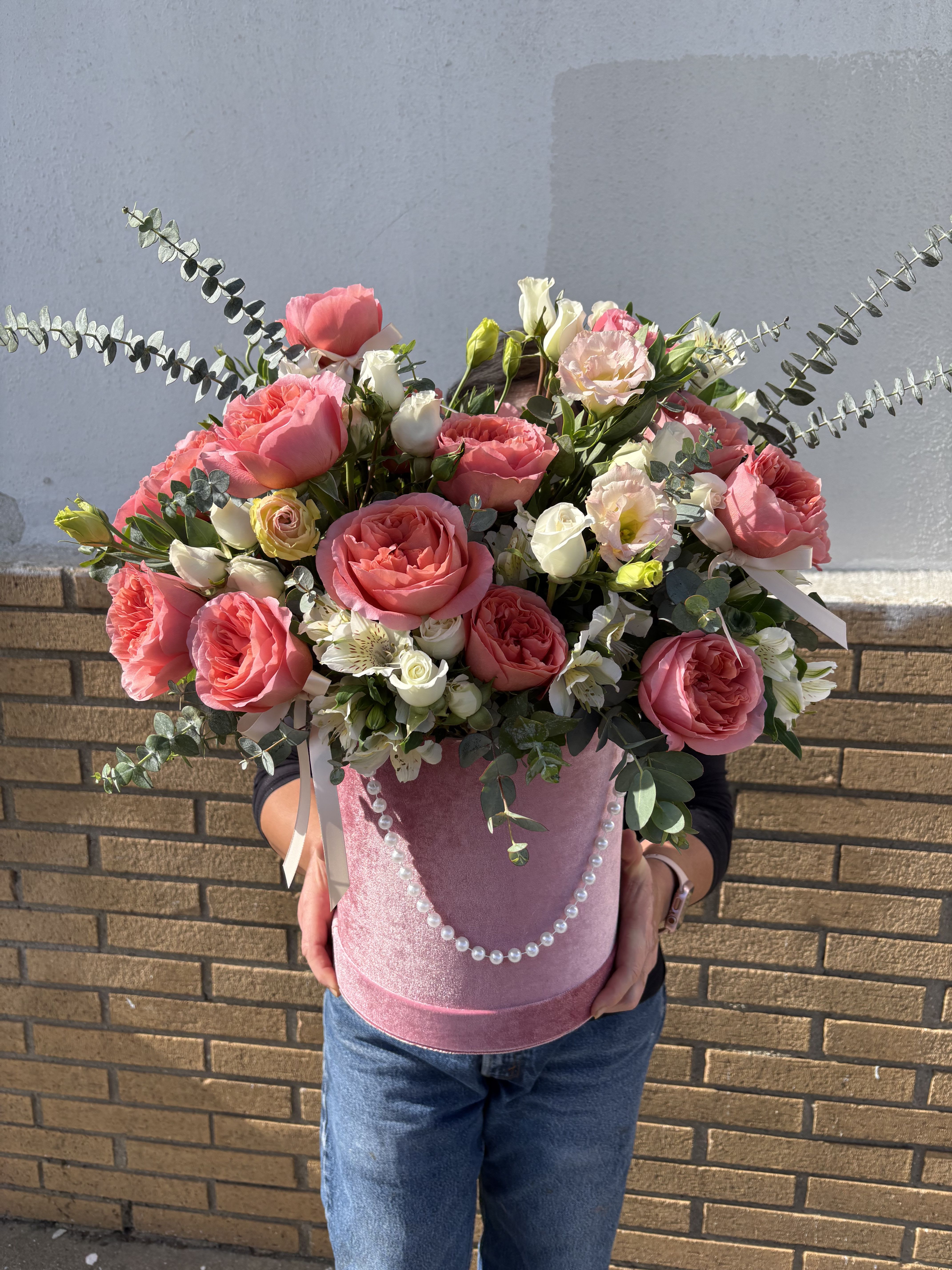 Pink roses and white blooms in a pink hatbox with pearl trim
