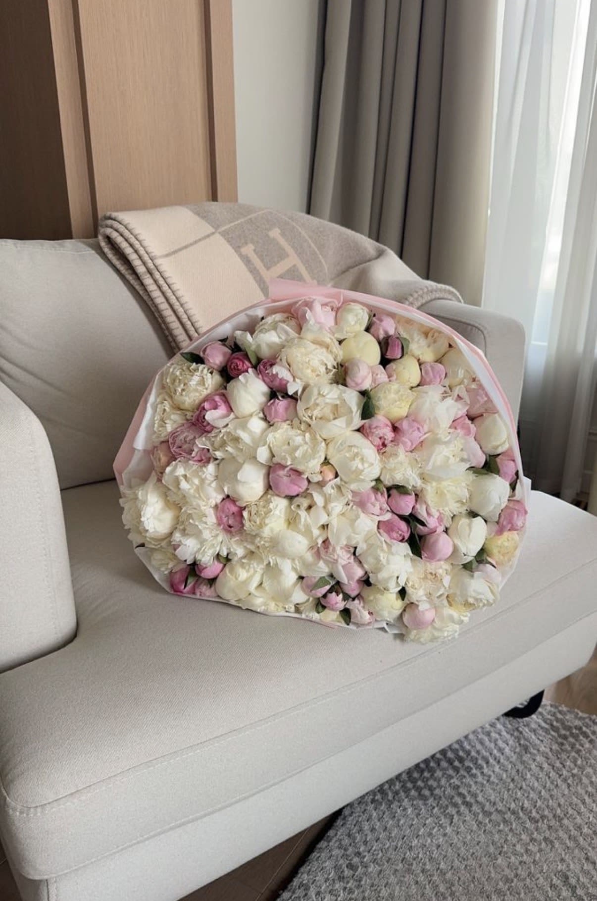 Large bouquet of pale pink and white flowers wrapped in pink paper