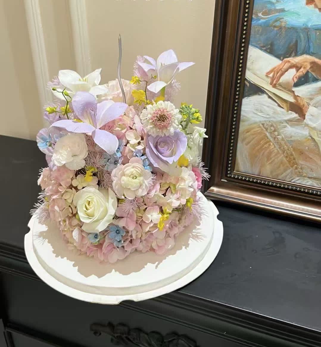 Pastel floral arrangement on a white round base
