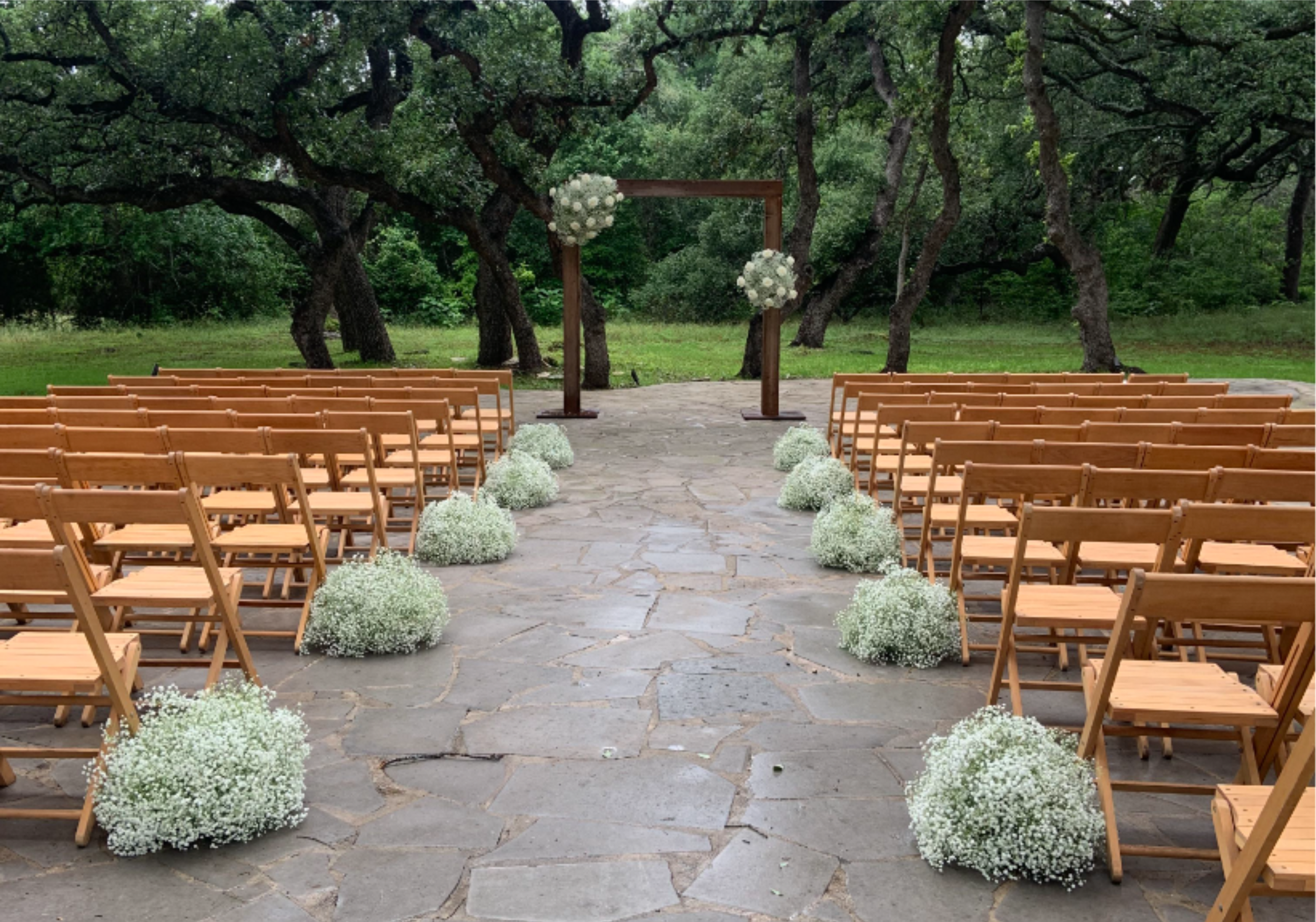 The Aisle Meadow Cloud Collection - The Essential (Standard) The Vibe: Airy, delicate, and charming.  Description: A budget-conscious way to bring the popular "growing garden" look to your ceremony. Crafted with lush, airy greenery and beautiful secondary blooms to create a light, whimsical cloud effect along your aisle.  The Signature (Deluxe) The Vibe: Lush, classic, and beautifully balanced.  Description: Our most popular size, offering a full and substantial floral presence. Features a premium mix of focal flowers (like roses and ranunculus) nestled deeply into a rich, dense bed of seasonal greenery.  The Luxe (Premium) The Vibe: Lavish, overflowing, and breathtaking.  Description: A statement-making, high-impact installment designed for maximum luxury. An oversized, sprawling arrangement packed with top-tier premium blooms to create a dense, magnificent floral border. Delivery and Installation may be purchased separately. Must purchase a minimum of 2 