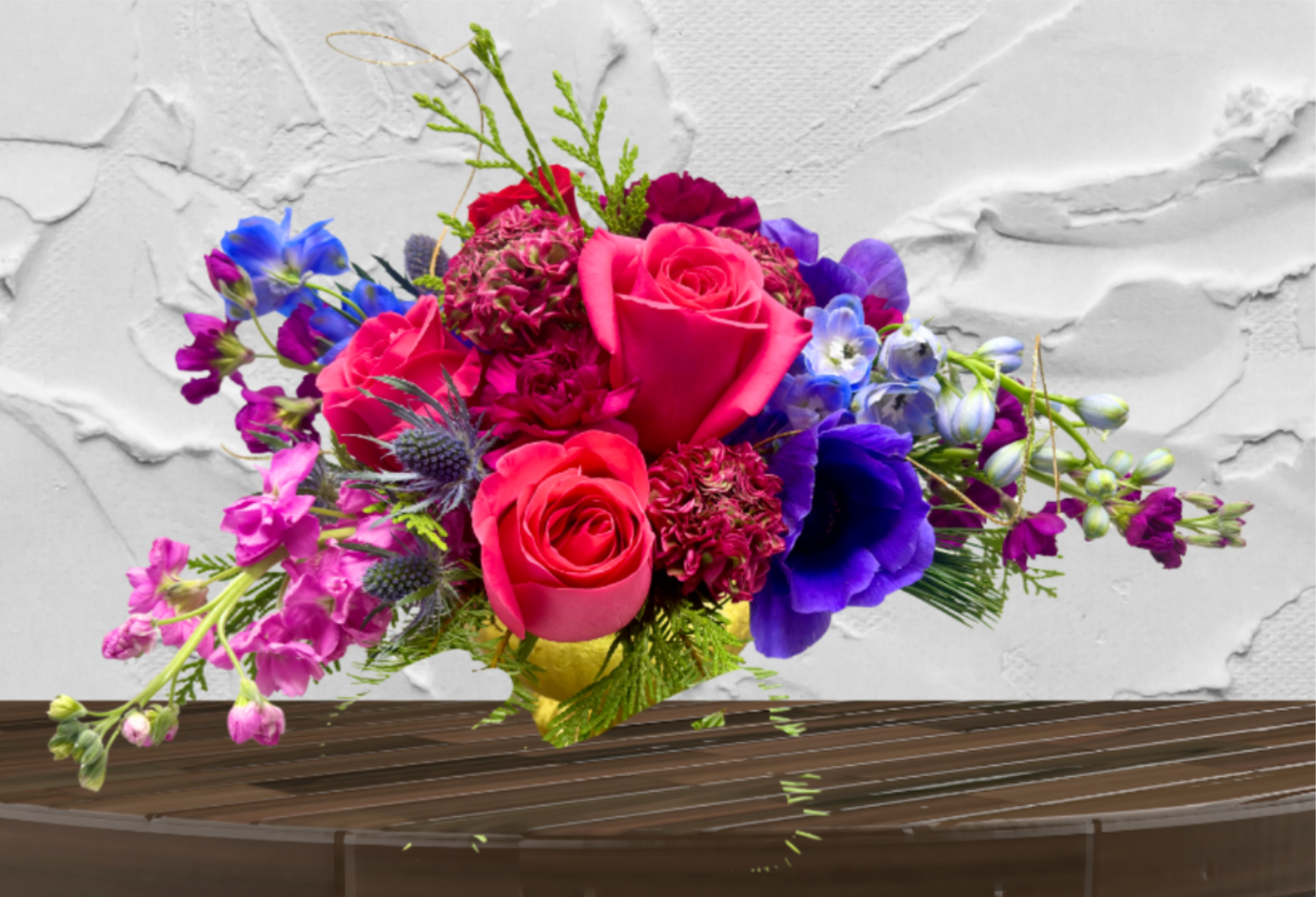 Velvet Romance Centerpiece - "Hand-crafted by accredited Master Florist Tricia Won (AIFD, EMC, IMF) using premium seasonal market blooms. No two arrangements are identical." Bold Artistry. Golden Elegance. Unforgettable Luxury.  The Velvet Romance is a masterclass in texture and tonal depth. This arrangement is designed for the bold at heart, blending deep, passionate crimsons with moody purples and delicate, ethereal accents. Every stem is chosen for its "wow" factor, creating a lush, rounded silhouette that commands attention from every angle.  The Design &amp; Florals This arrangement showcases our "Vibrant &amp; Bold" weekly palette at its most luxurious.  Premium Blooms: Featuring a dense core of vibrant seasonal garden style blooms.  Textural Accents: We’ve layered in seasonal greenery, delicate gold-toned fillers, and organic elements like miniature cones to provide a multi-dimensional, garden-to-table feel.  The Upscale Vessel: Presented in a stunning, footed golden compote with a ribbed, metallic finish. This heirloom-quality vessel adds a regal warmth to any setting and is designed to be a permanent treasure in your home.  Versatile Luxury While perfect as a statement piece for your dining table or entryway. Its sophisticated scale and rich color story provide a lavish focal point that feels both classic and contemporary.