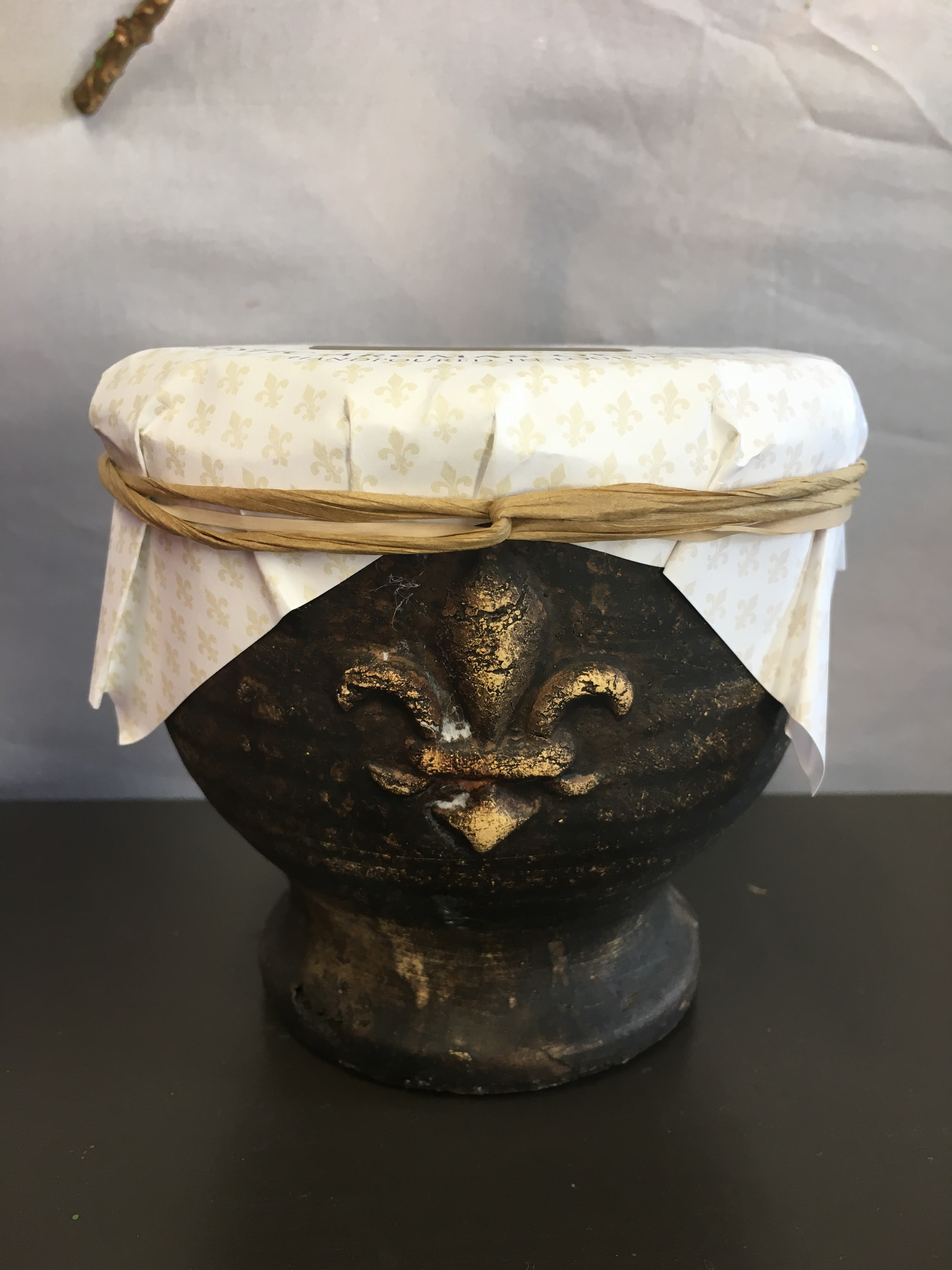 Decorative dark pedestal bowl with a white patterned cover and tied ribbon