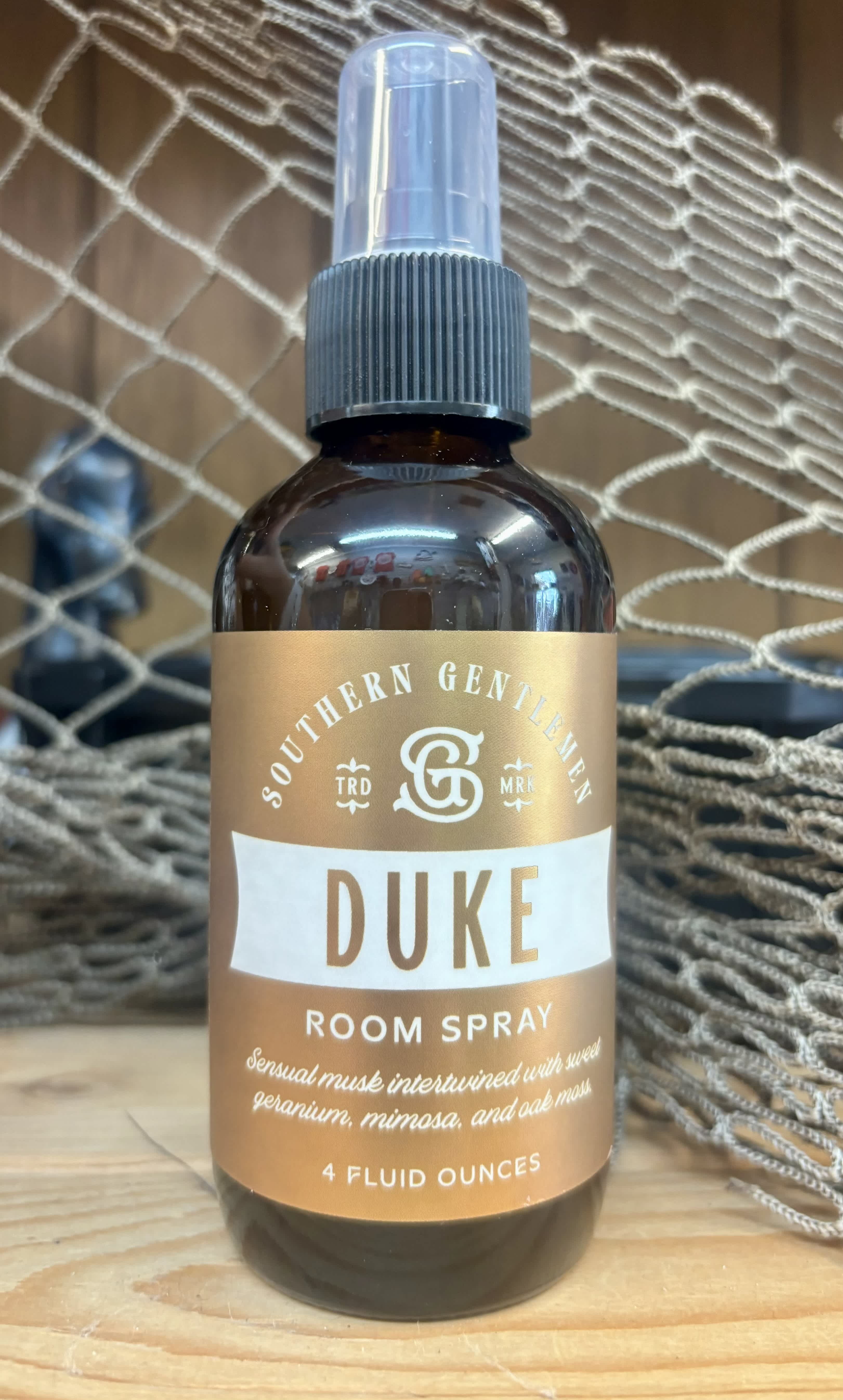Brown room spray bottle with a pump top and gold label