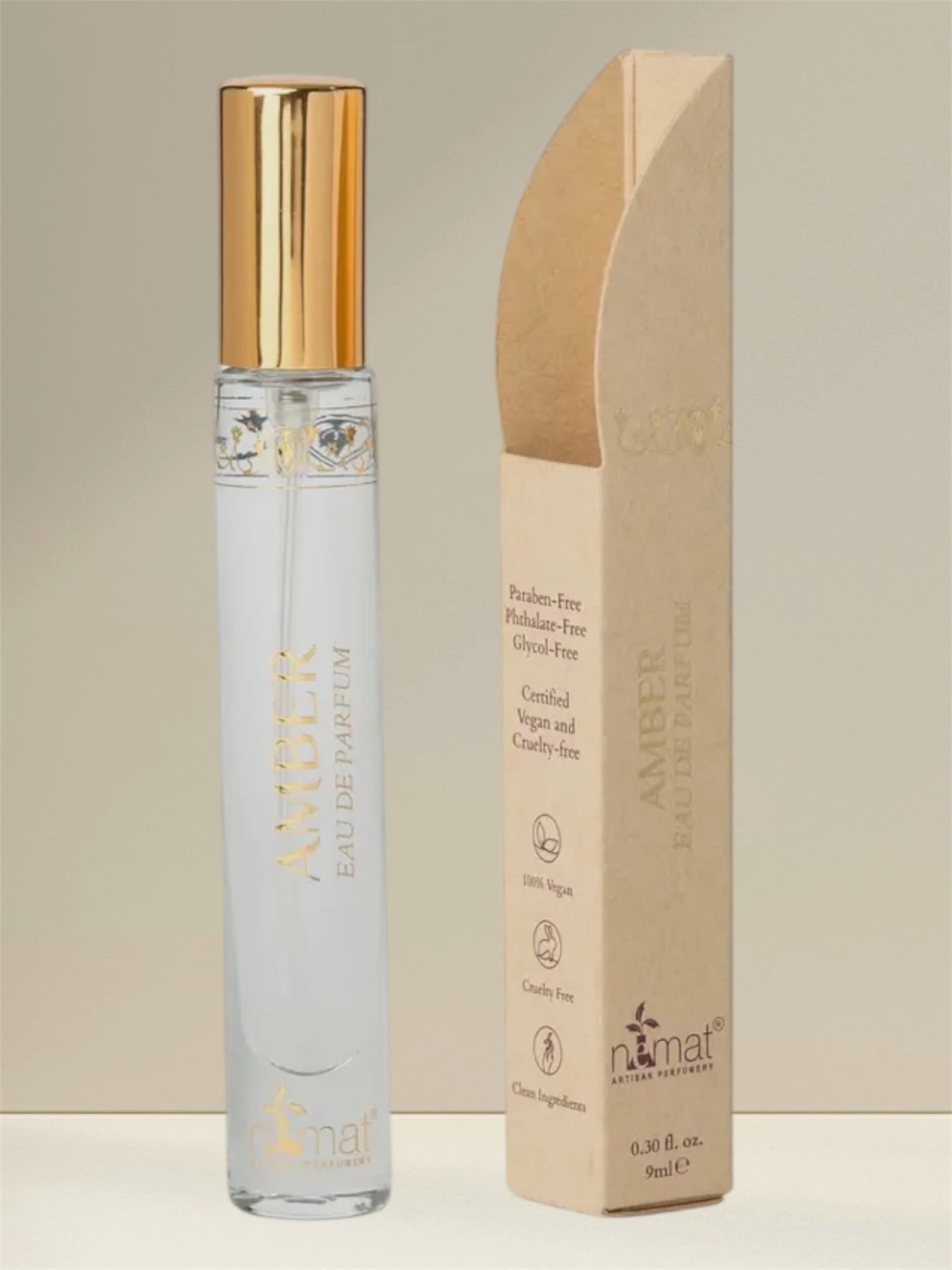 A perfume bottle with a gold cap beside its beige box