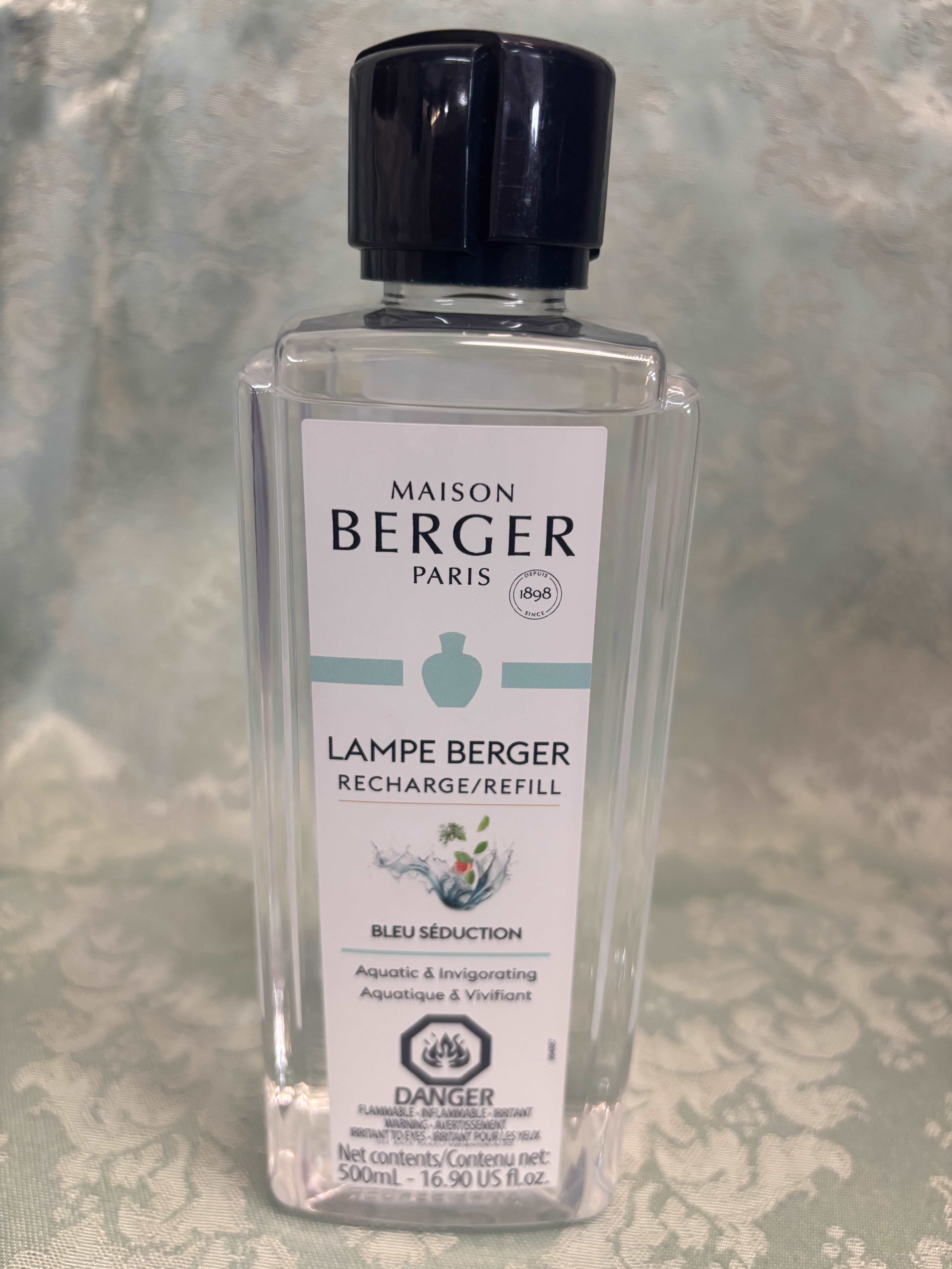 Clear bottle of Maison Berger Lampe Berger refill with a black cap