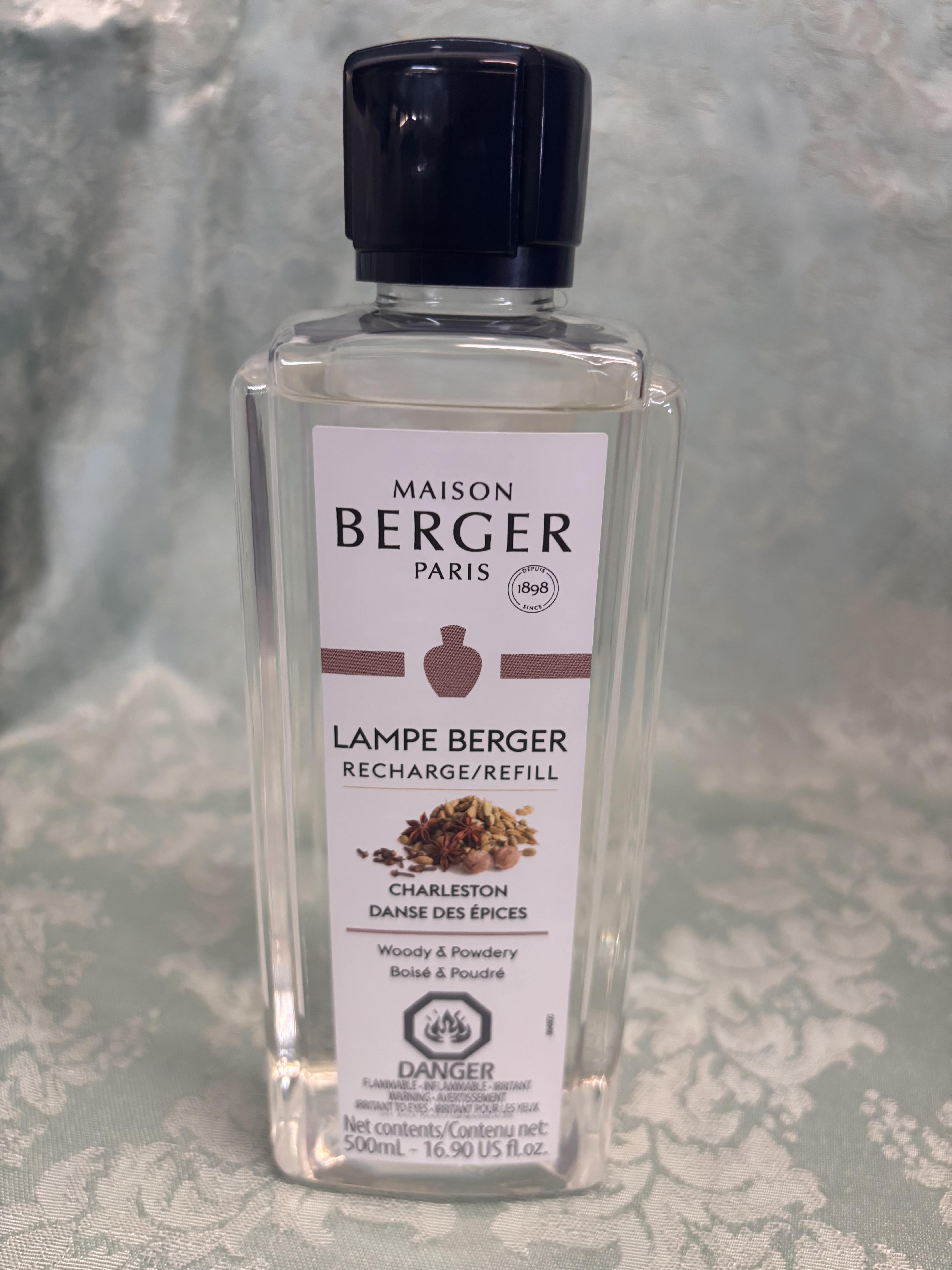 Clear bottle of Maison Berger Paris lamp refill with a dark cap