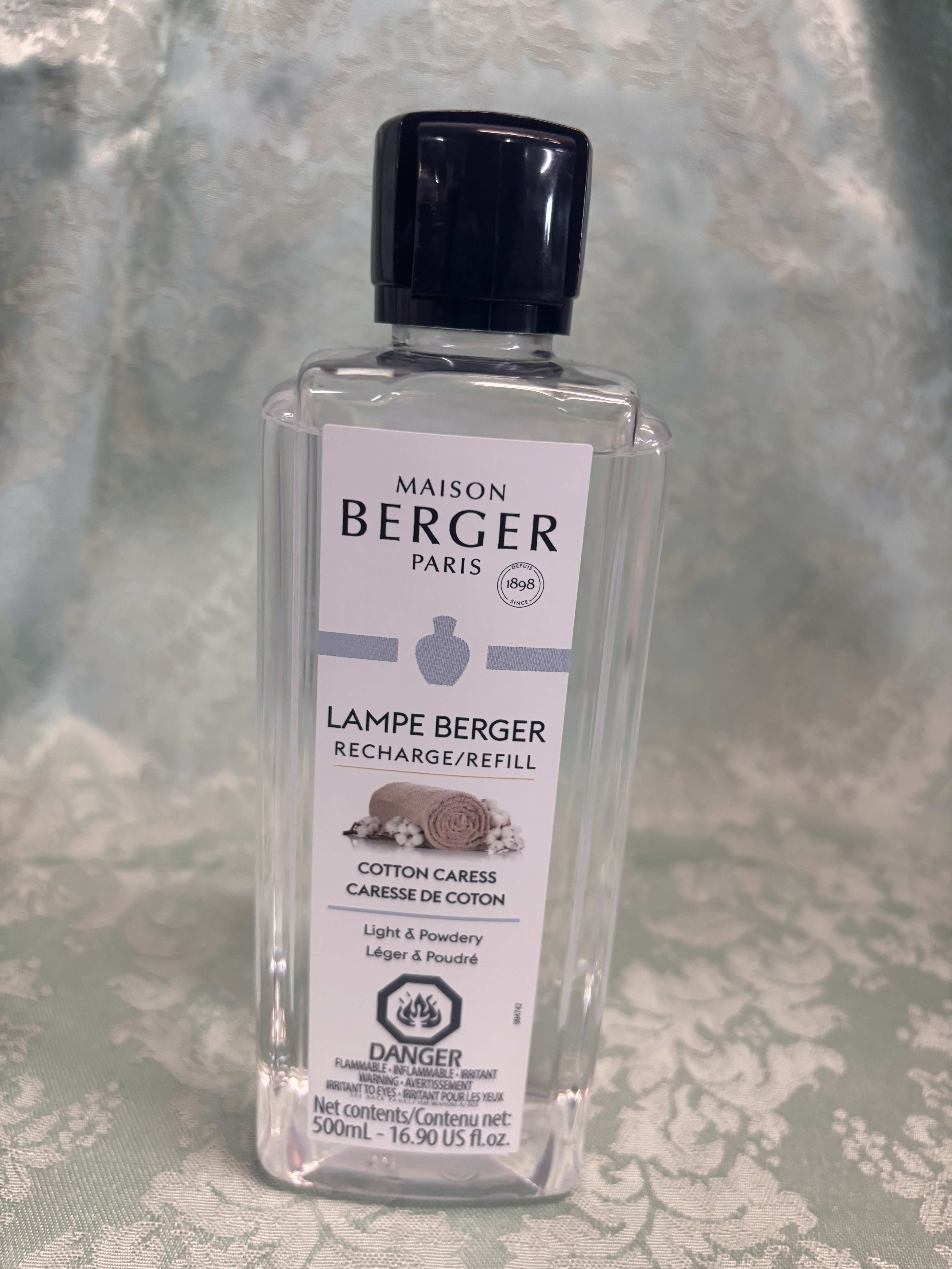 Clear bottle of Maison Berger Lampe Berger refill with black cap
