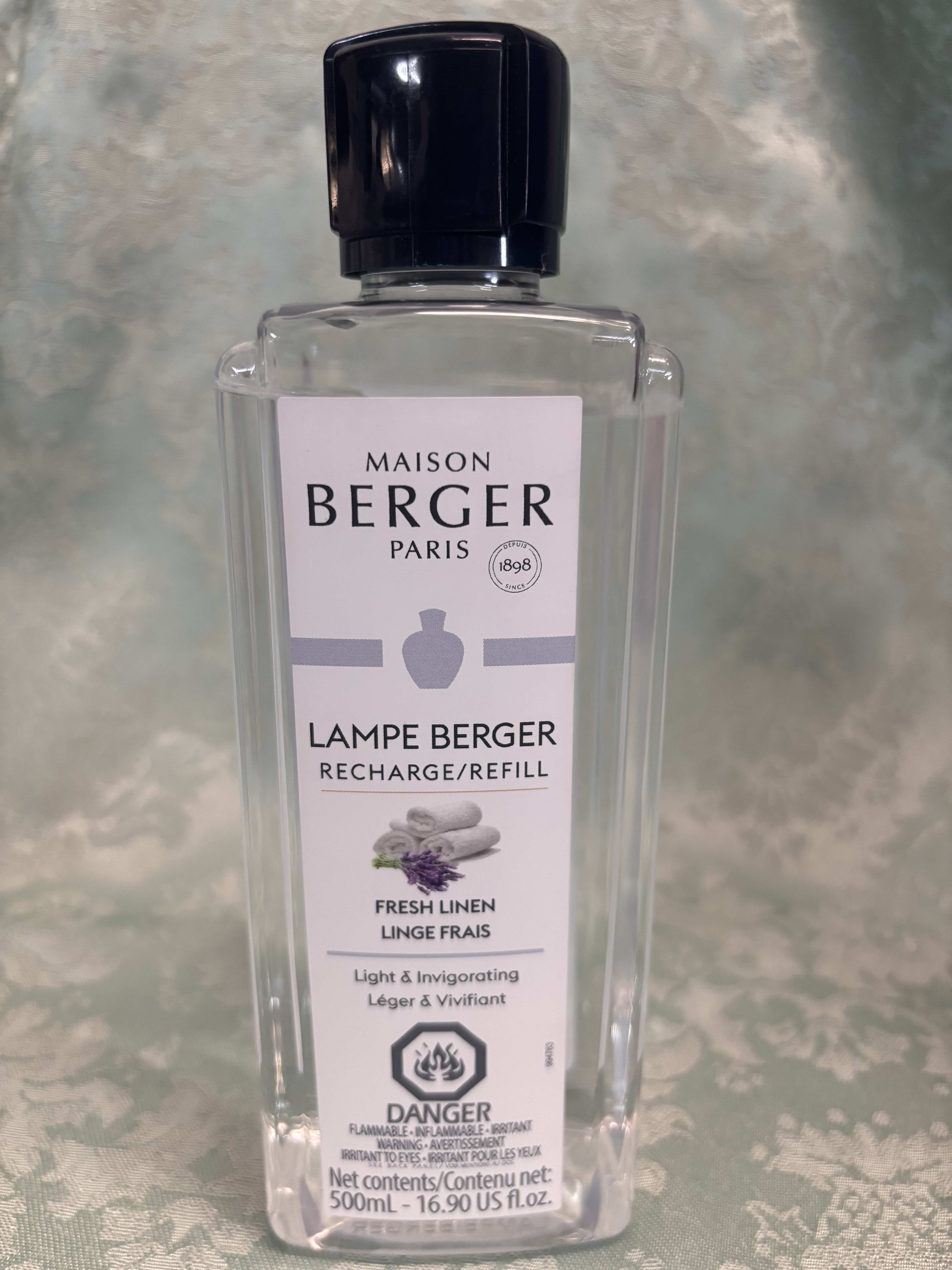 Clear bottle of Maison Berger Lampe Berger refill with black cap