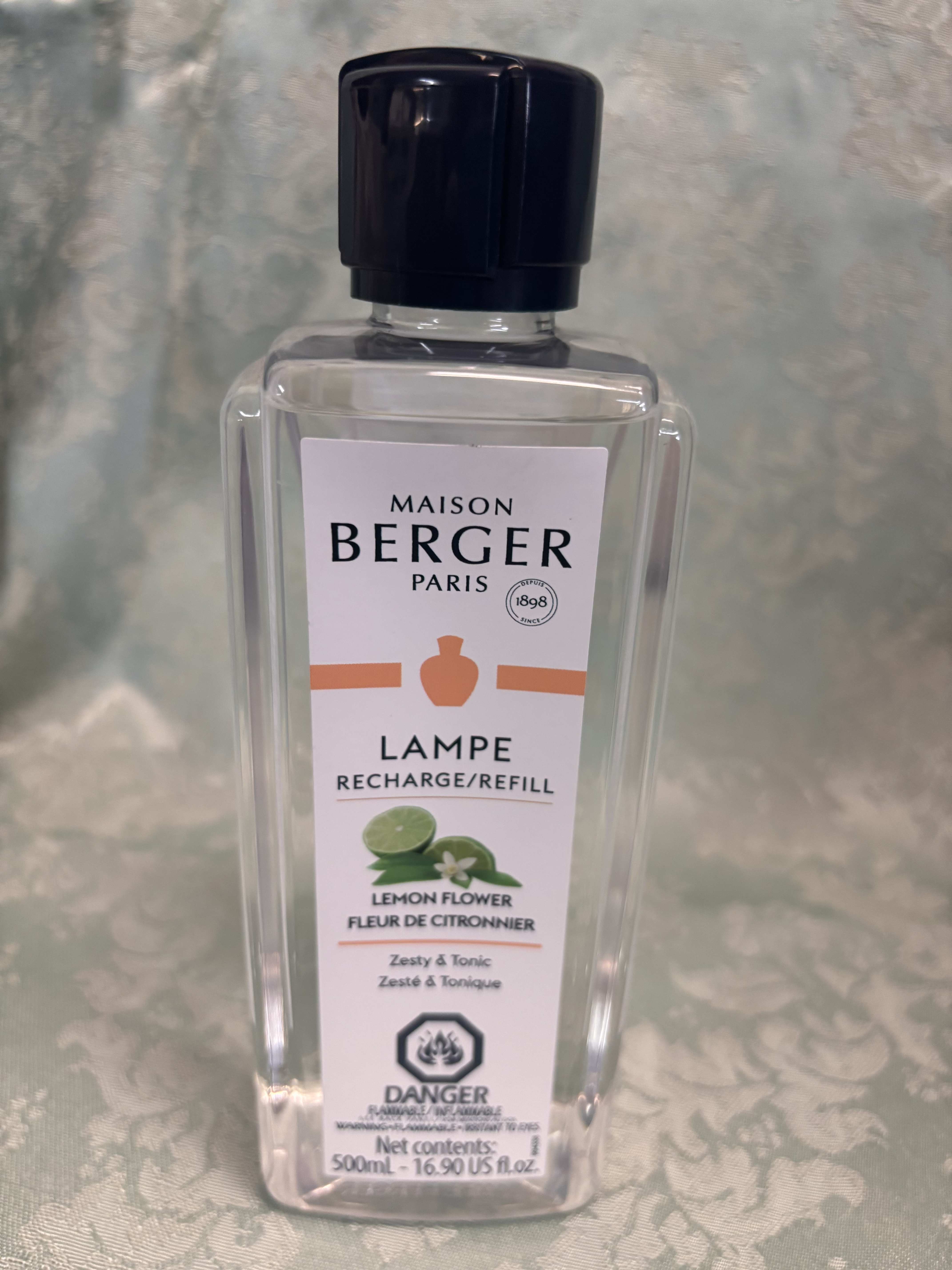 Clear bottle of Maison Berger lemon flower lamp refill with black cap