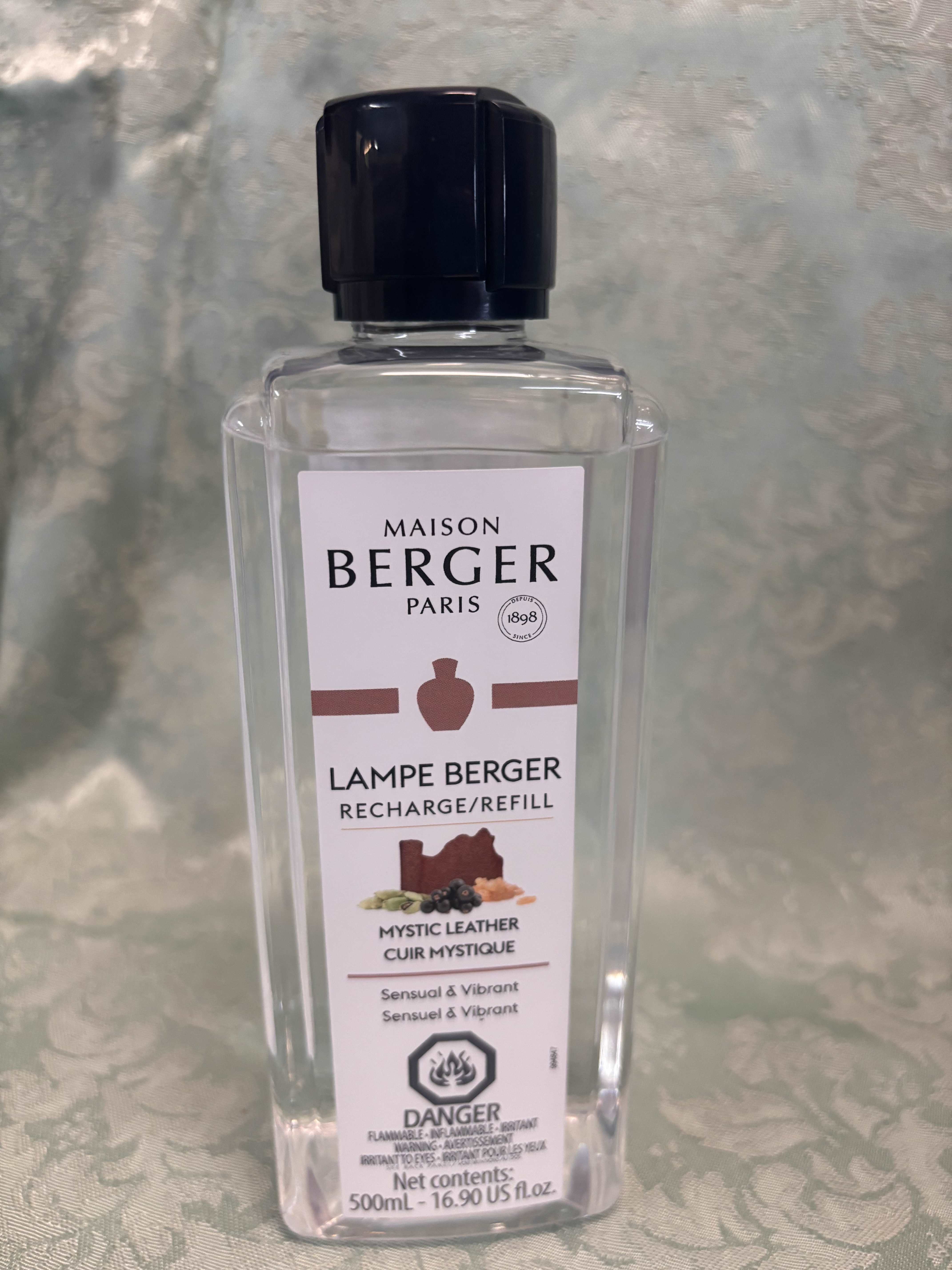 Clear bottle of Maison Berger Paris lamp refill with a black cap