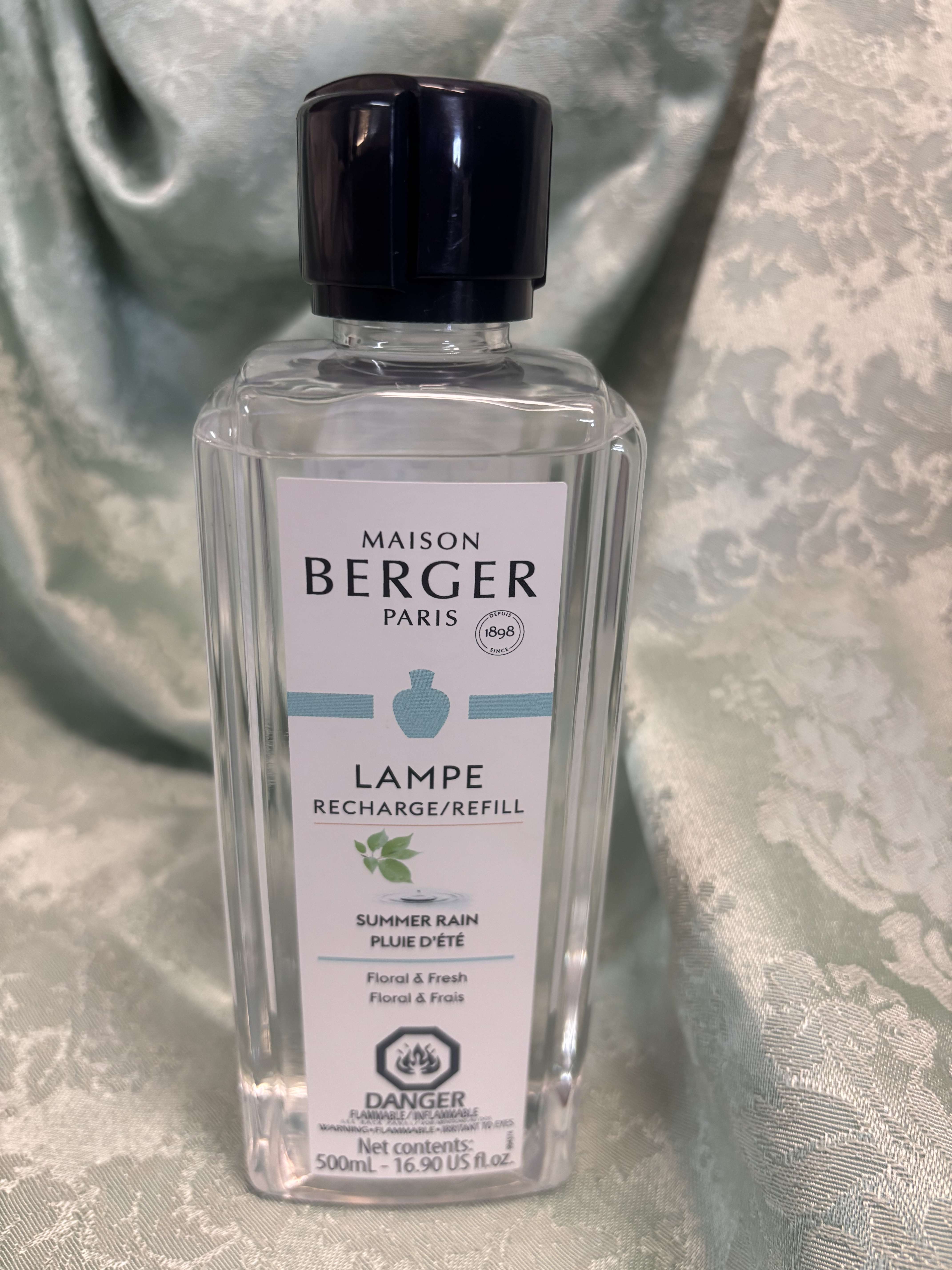 Clear bottle of Maison Berger Paris lamp refill with a black cap