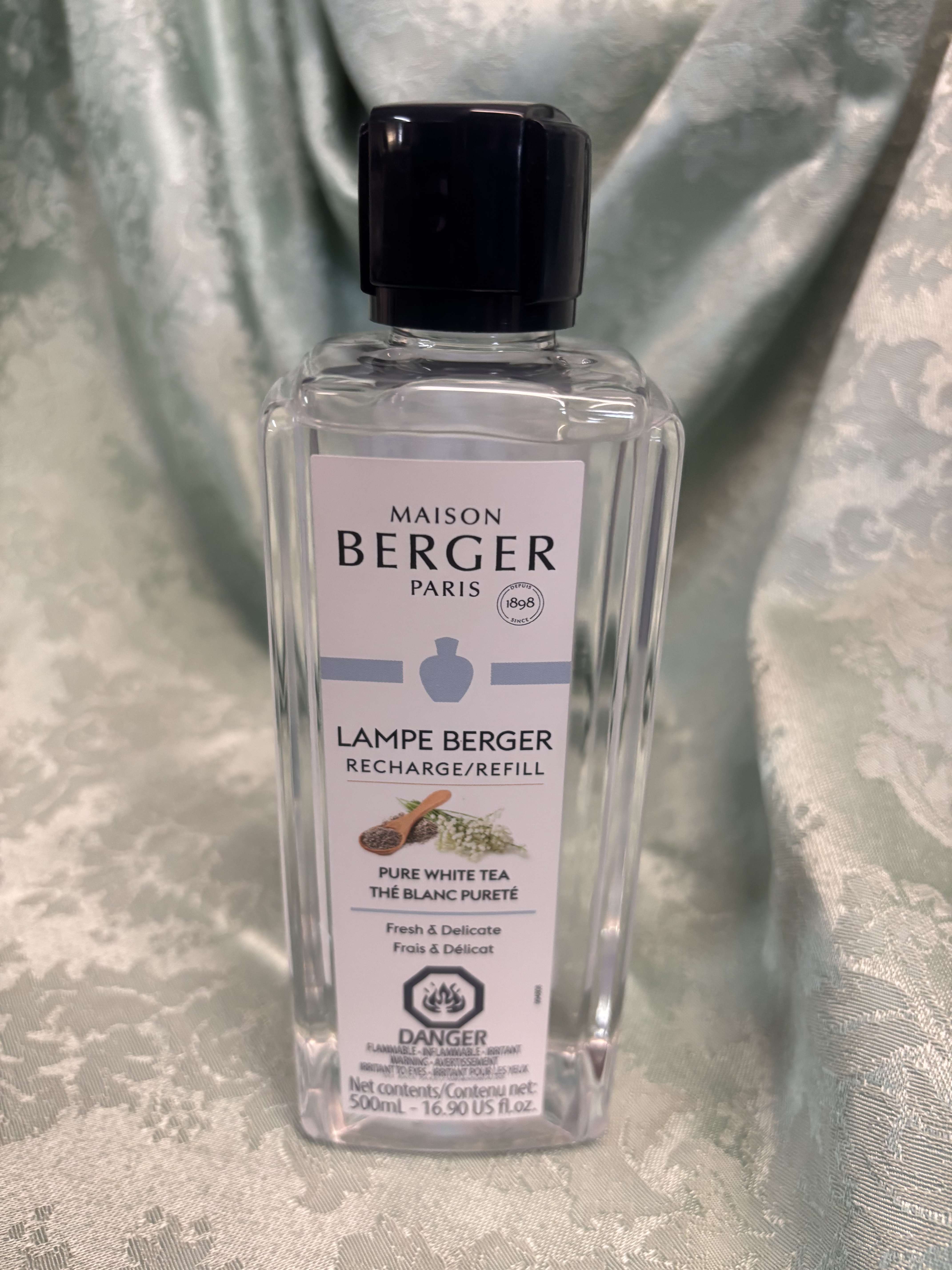 Clear bottle of Maison Berger Pure White Tea refill with a black cap