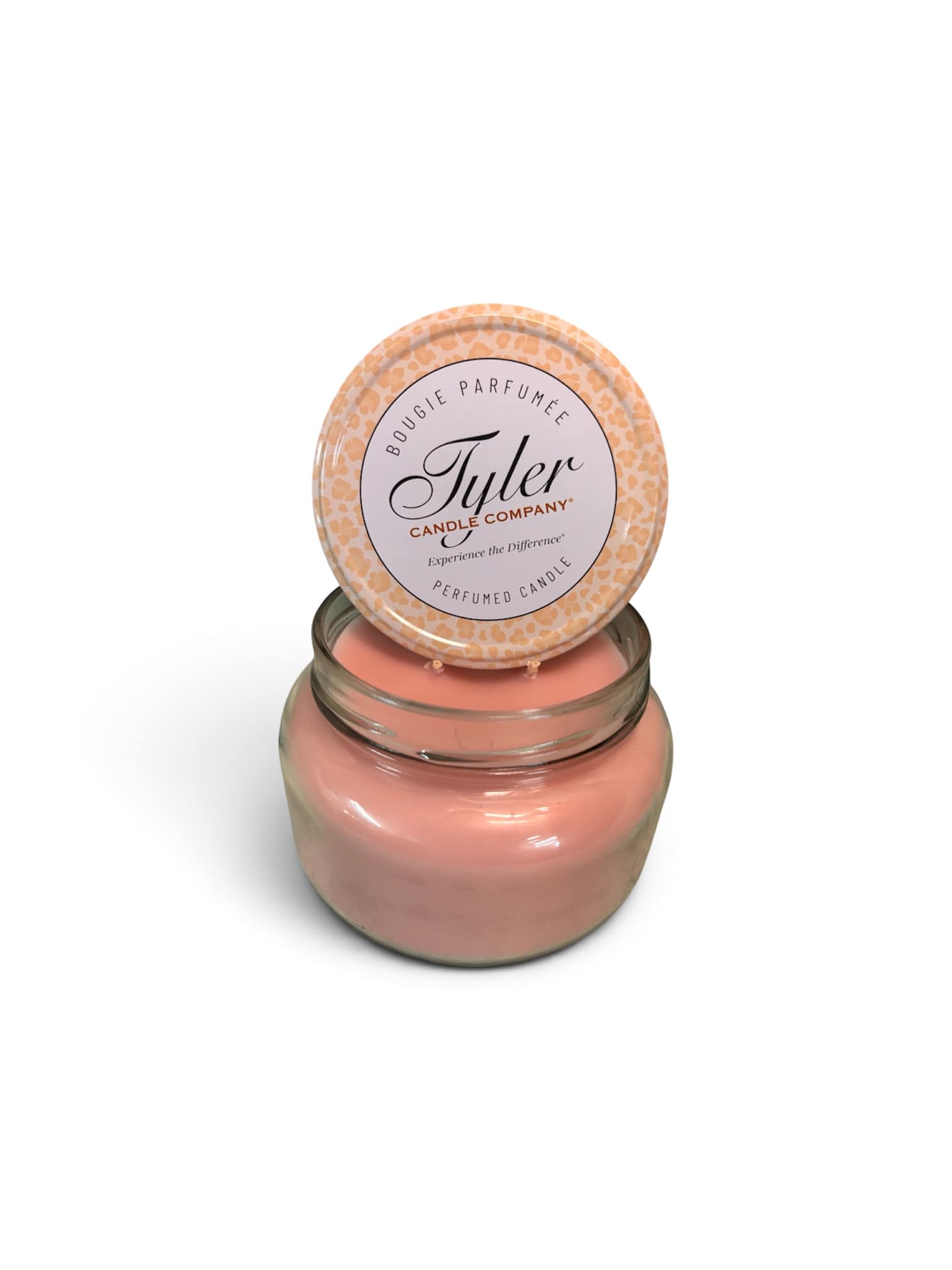 Pink scented candle in a glass jar with a patterned lid