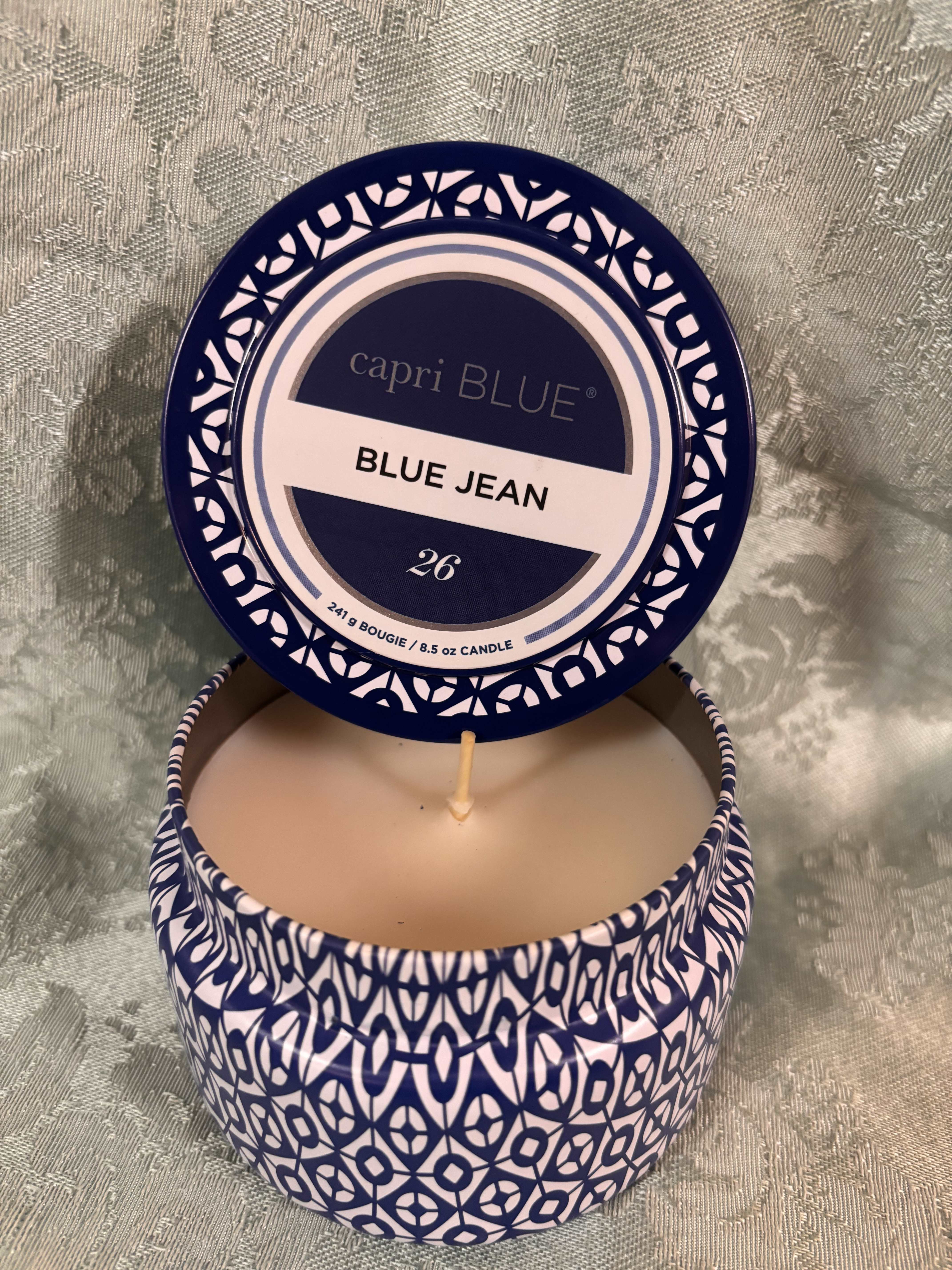 Blue and white scented candle in a patterned tin with the lid open