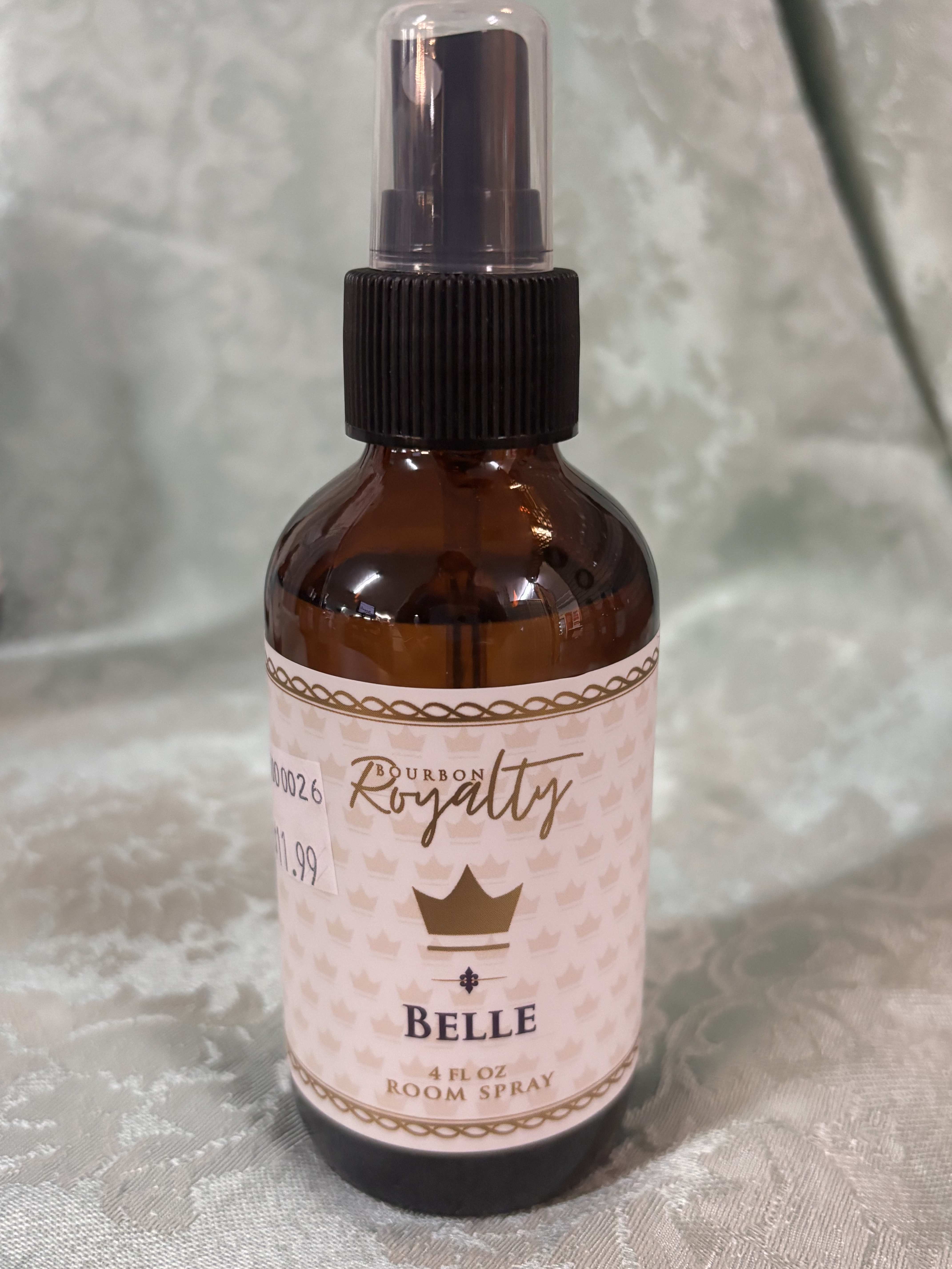 Amber room spray bottle with a black pump and pink label