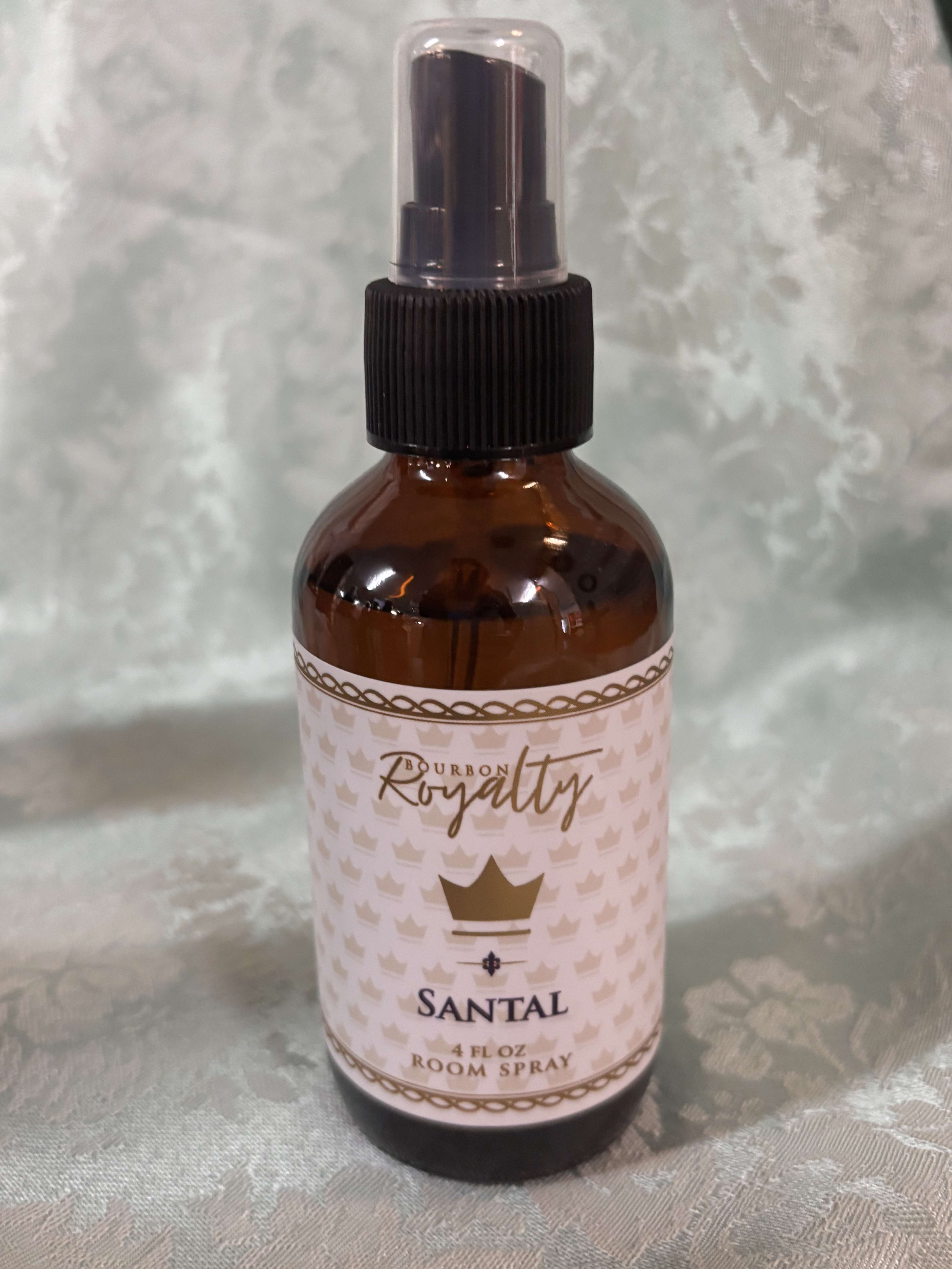 Amber room spray bottle with a black pump and pink label