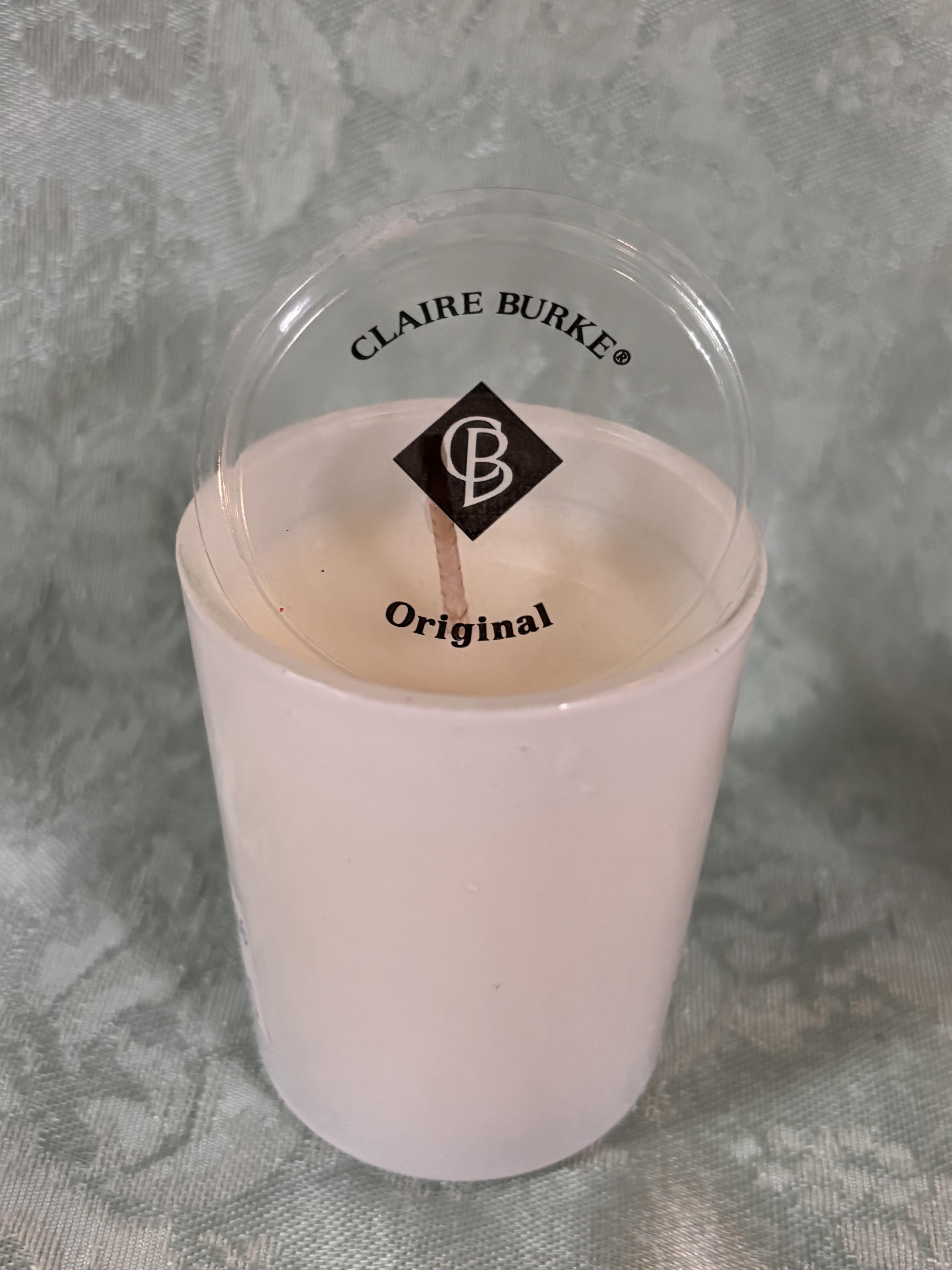 Pink candle in a clear plastic cup with a lid
