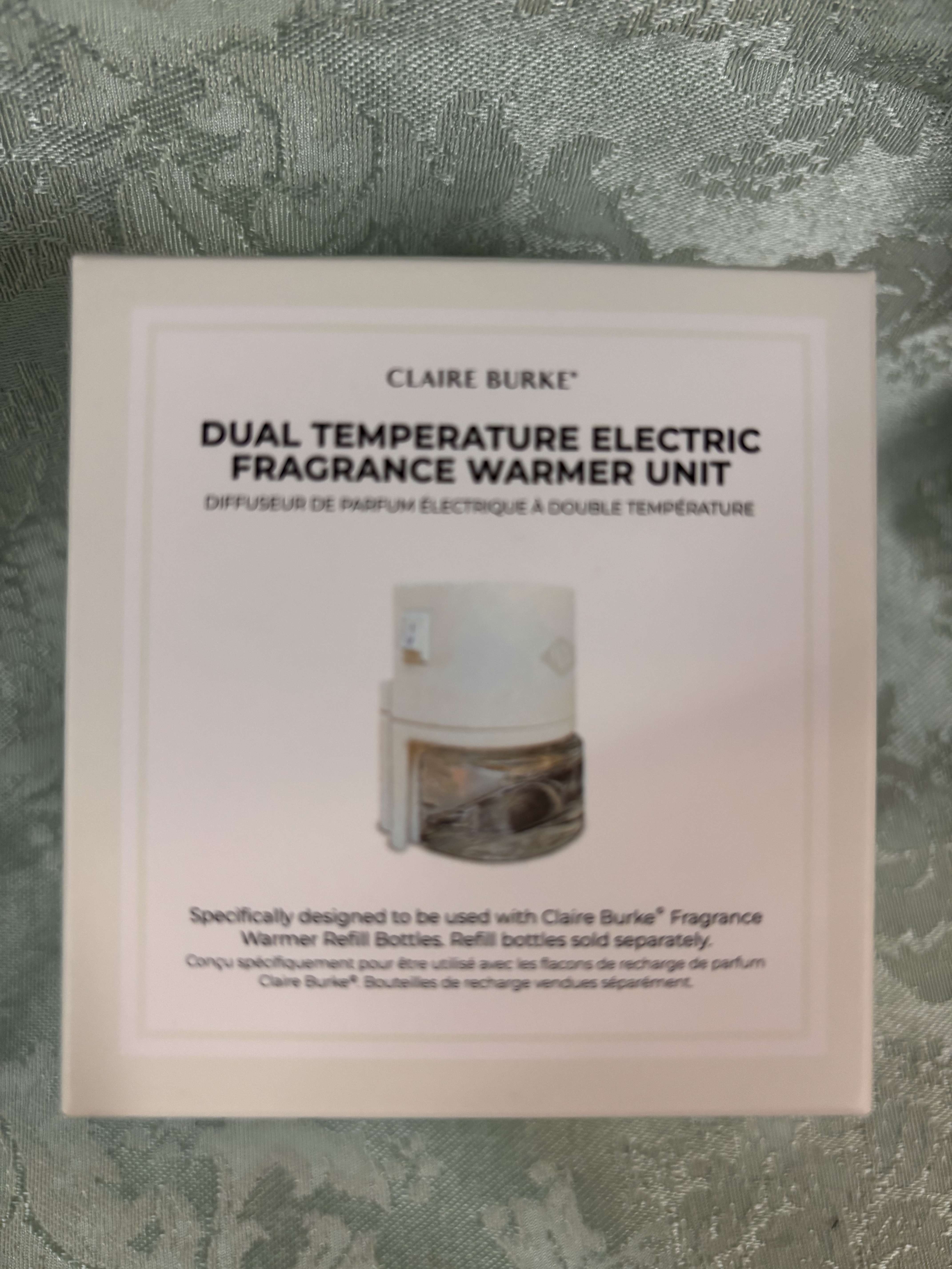 Boxed Claire Burke electric fragrance warmer unit on patterned fabric