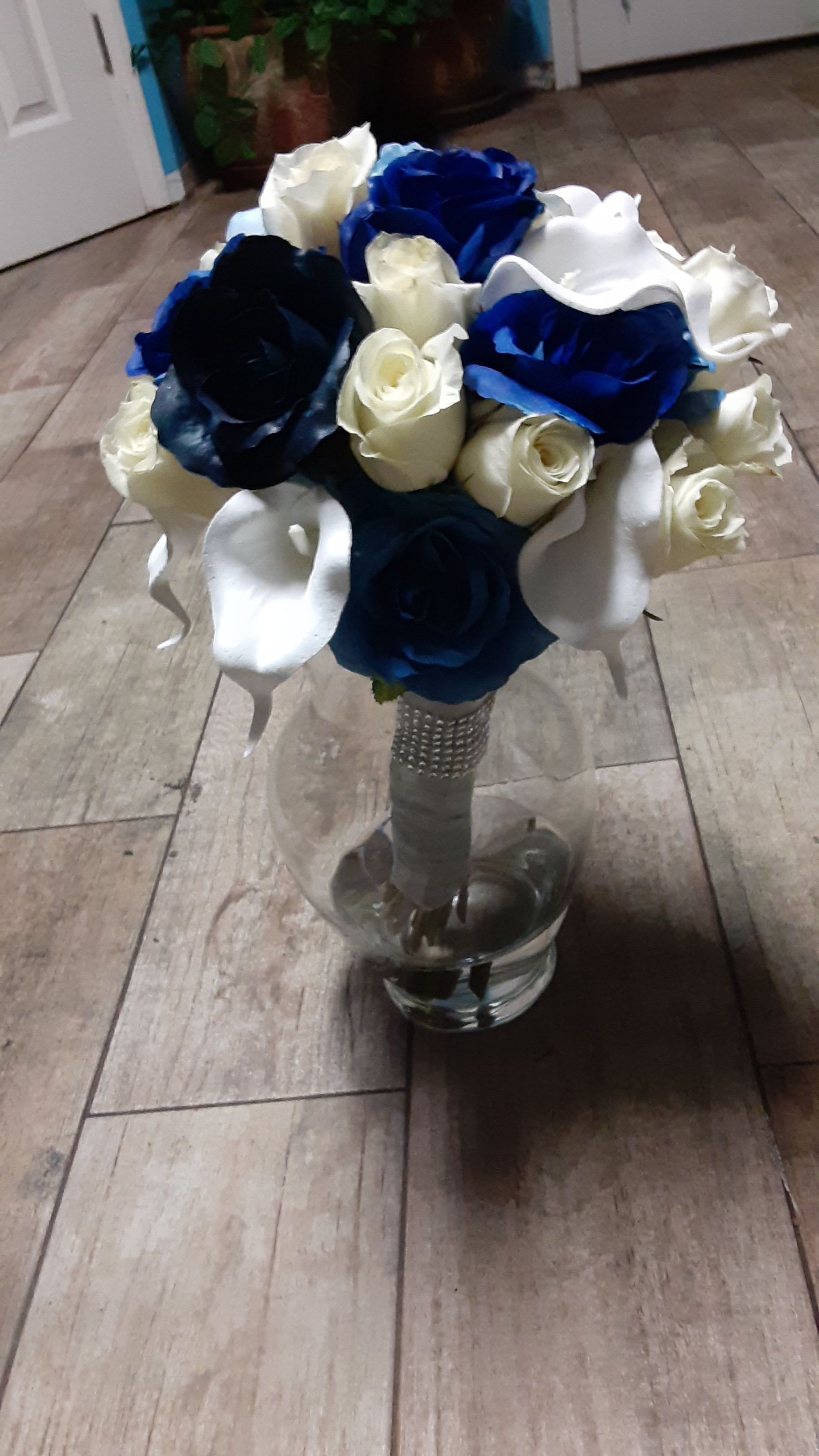 Bouquet of blue, white, and cream roses in a glass vase