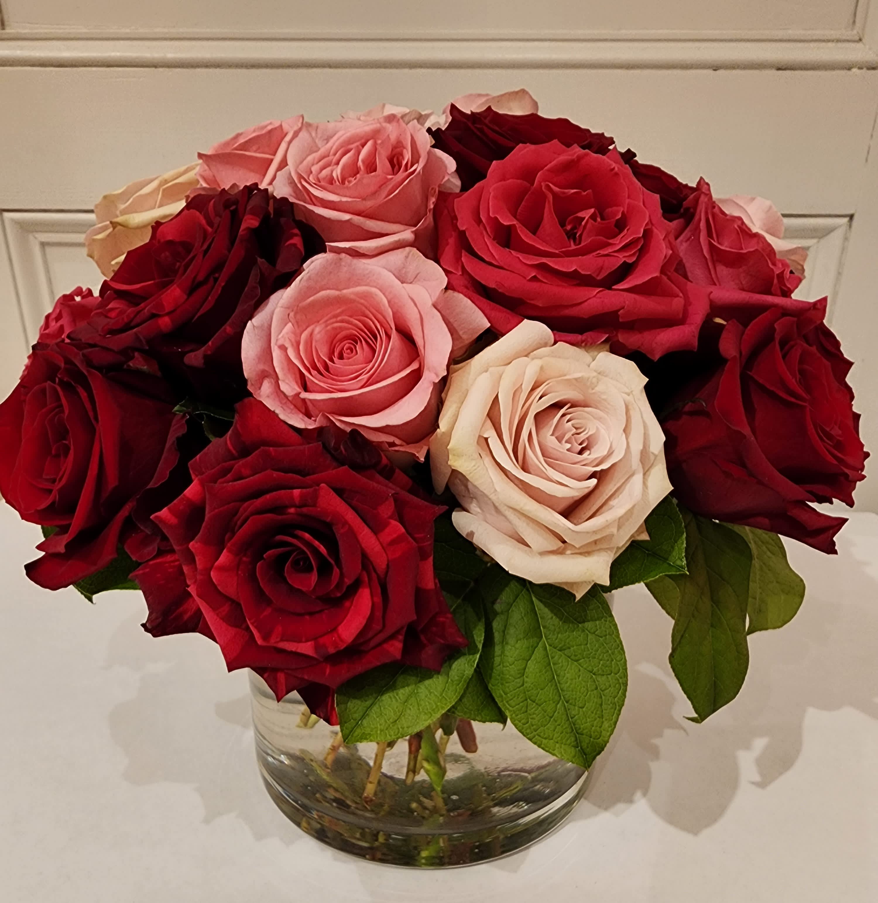 Bouquet of red and pink roses in a clear glass vase