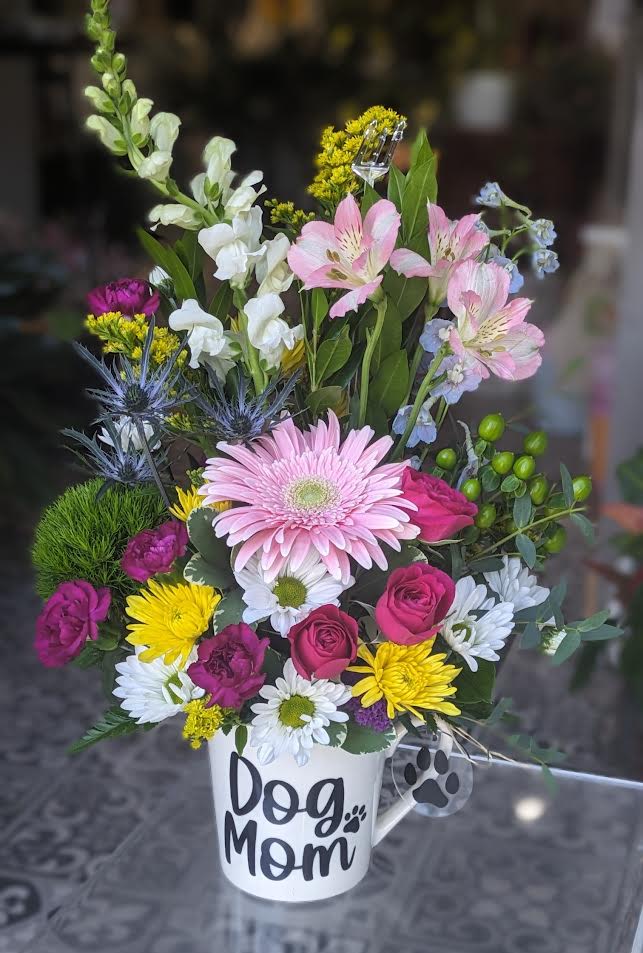 Mixed flower arrangement in a white mug labeled Dog Mom