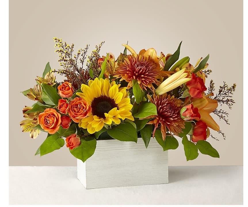 Mixed bouquet of sunflowers, orange roses, and lilies in a white box