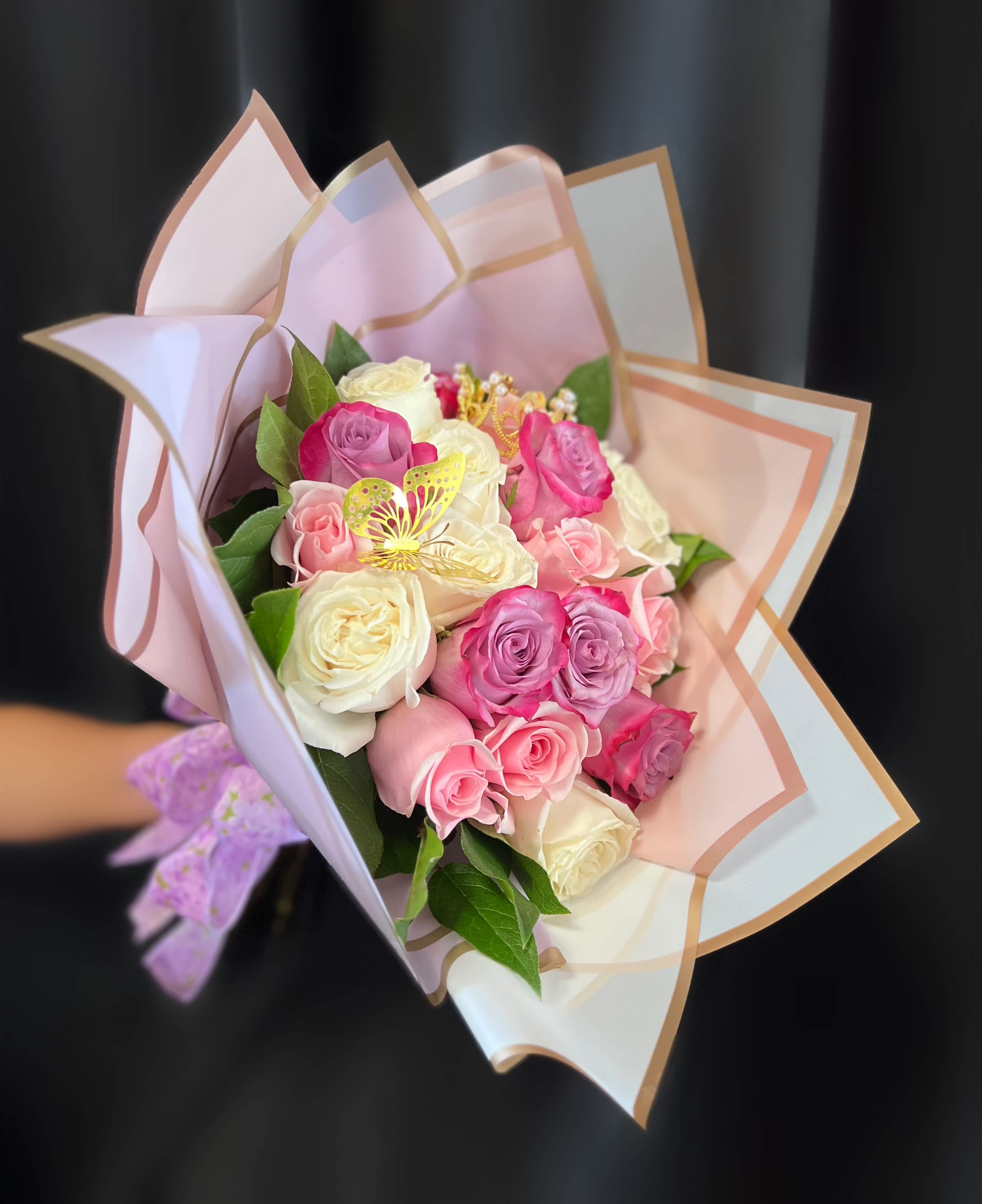 Bouquet of pink and white roses wrapped in pastel paper