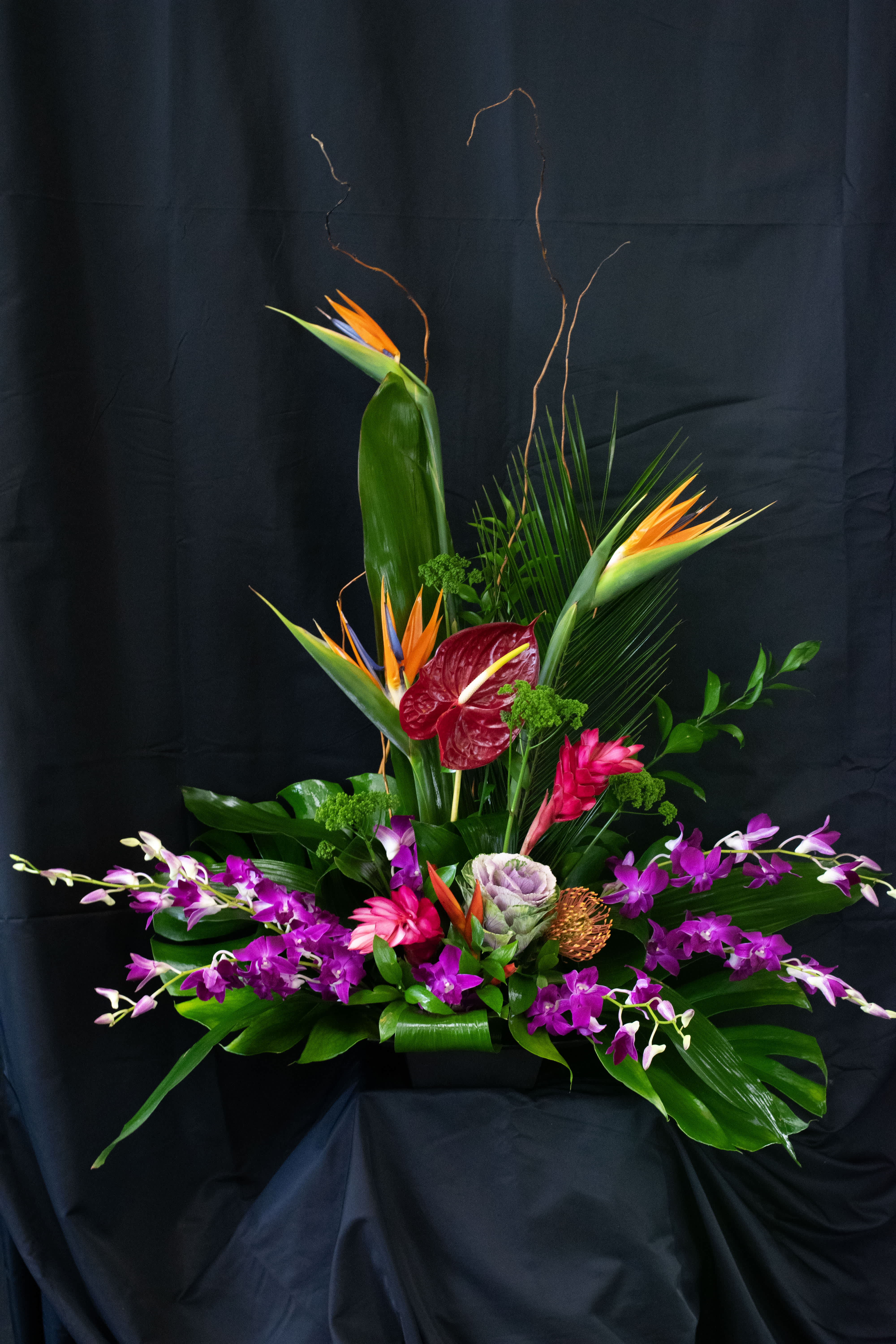 Tropical floral arrangement with orchids, anthurium, and bird of paradise