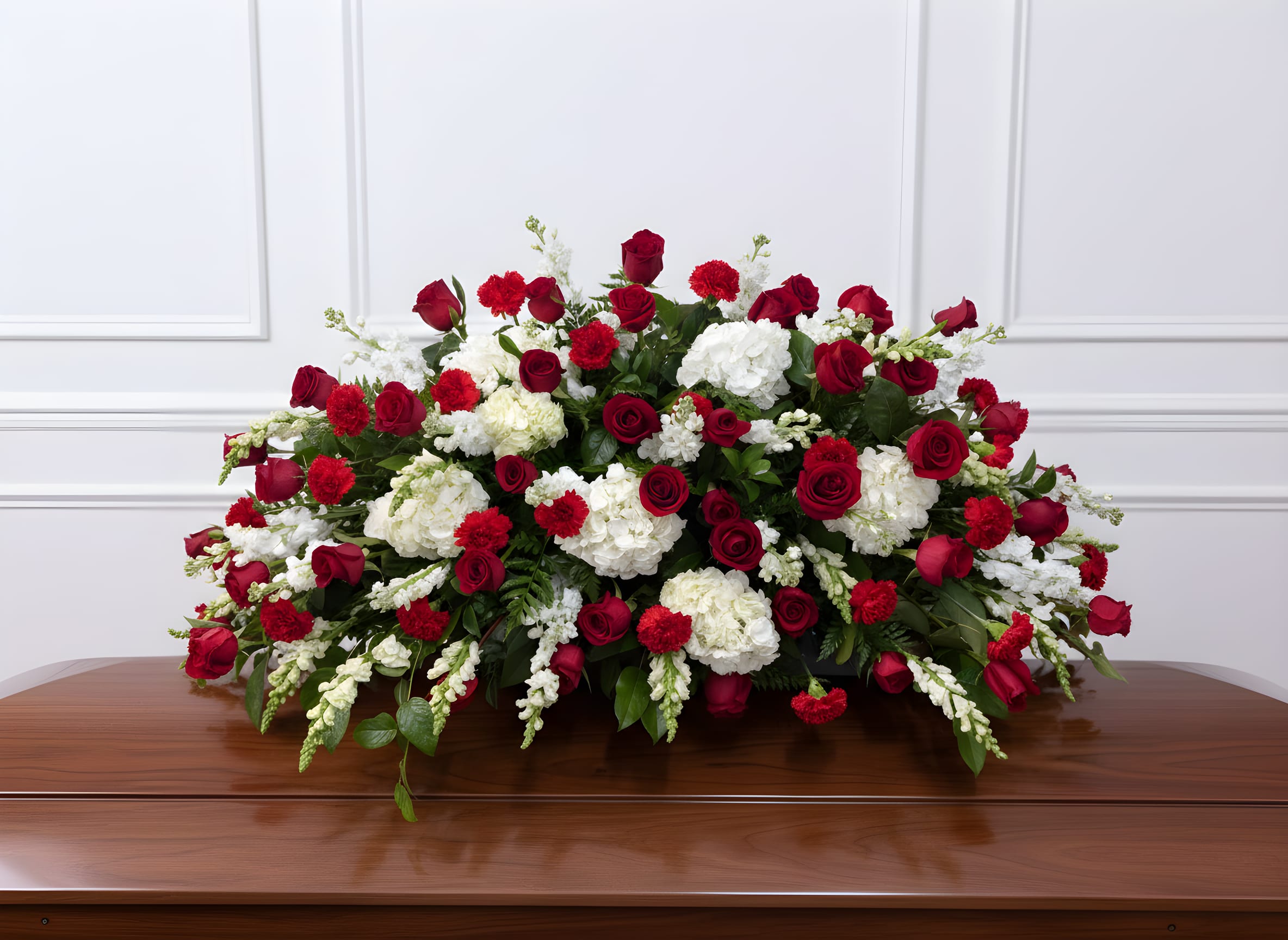 Red roses and white carnations arranged on a casket