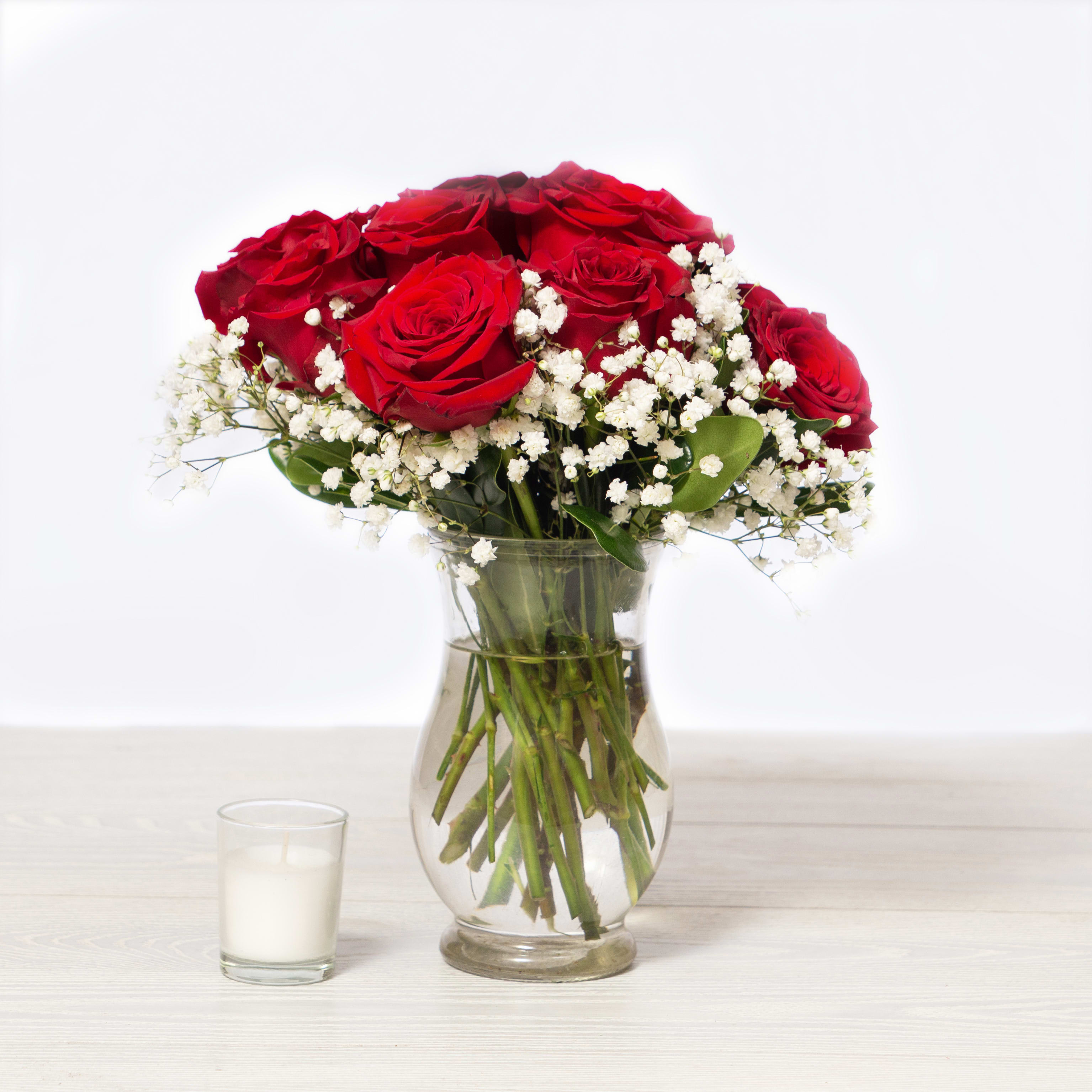 Red roses and white baby's breath in a clear glass vase