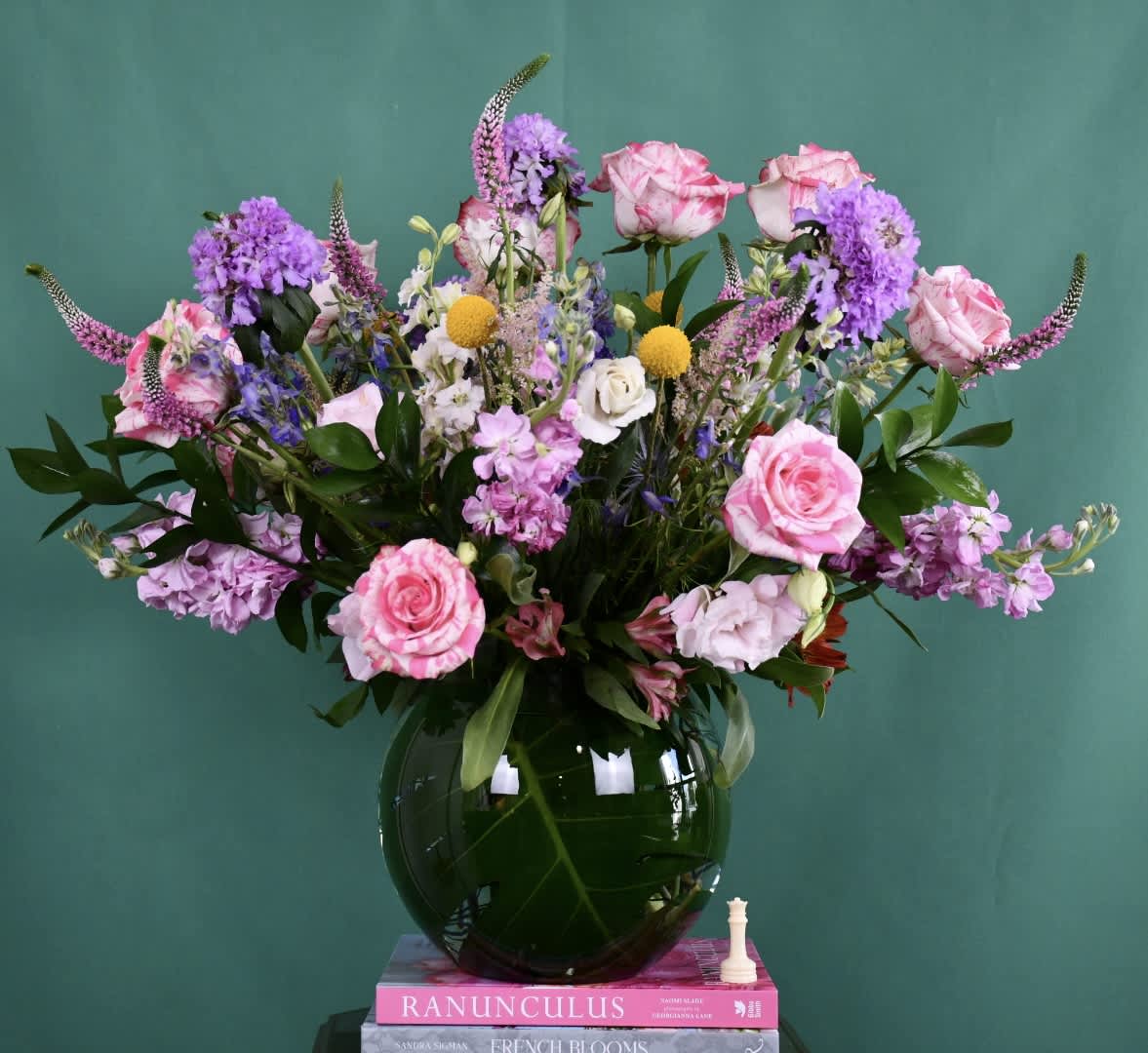 Pink and purple mixed bouquet in a dark glass vase